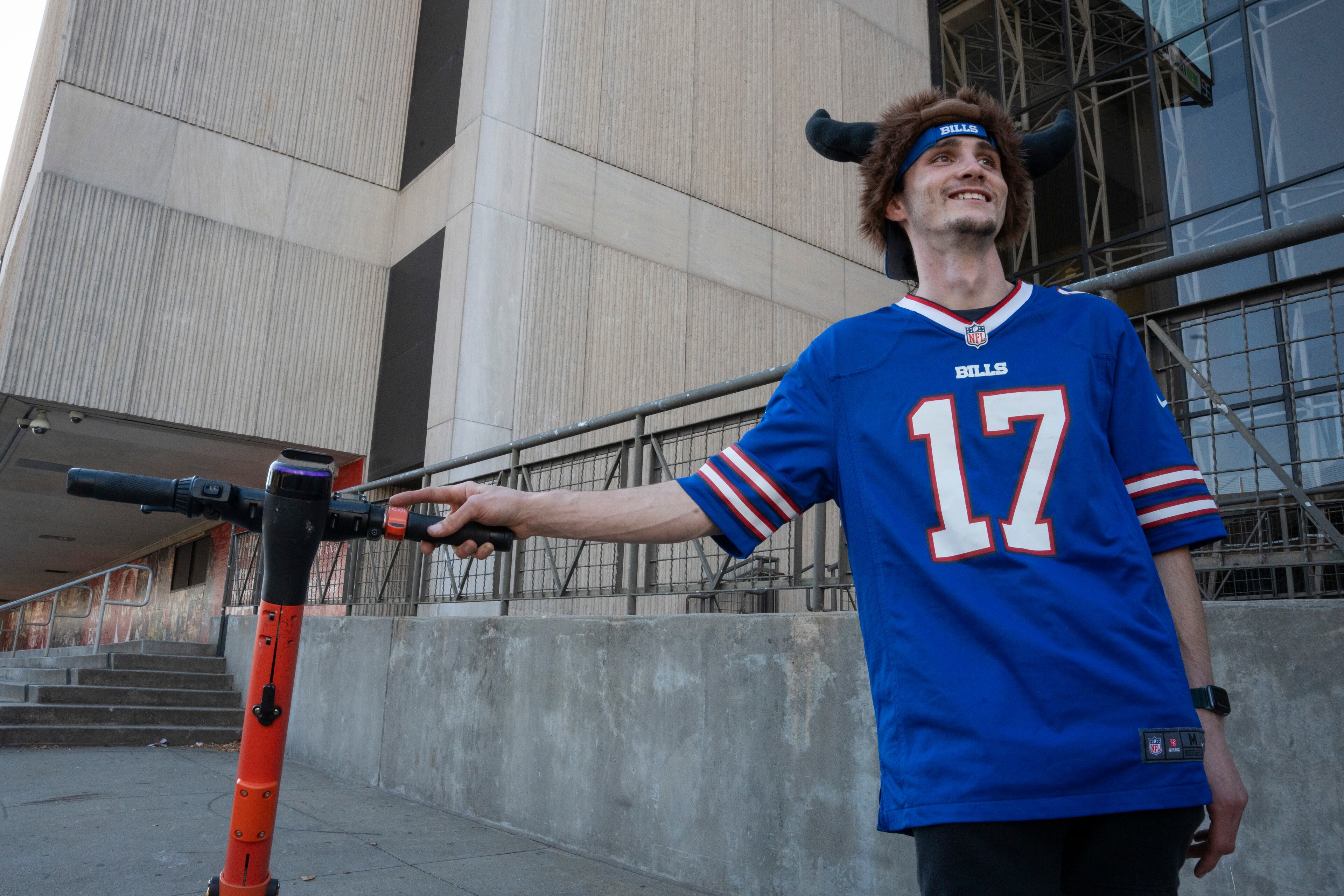 Dawson Bailey, from Chattanooga, poses in a Buffalo Bills jersey while riding a scooter near Mercedes-Benz Stadium on Sunday, Oct. 13, 2025, in Atlanta, ahead of the Monday Night Football game between the Bills and the Falcons. (Olivia Bowdoin for the AJC)