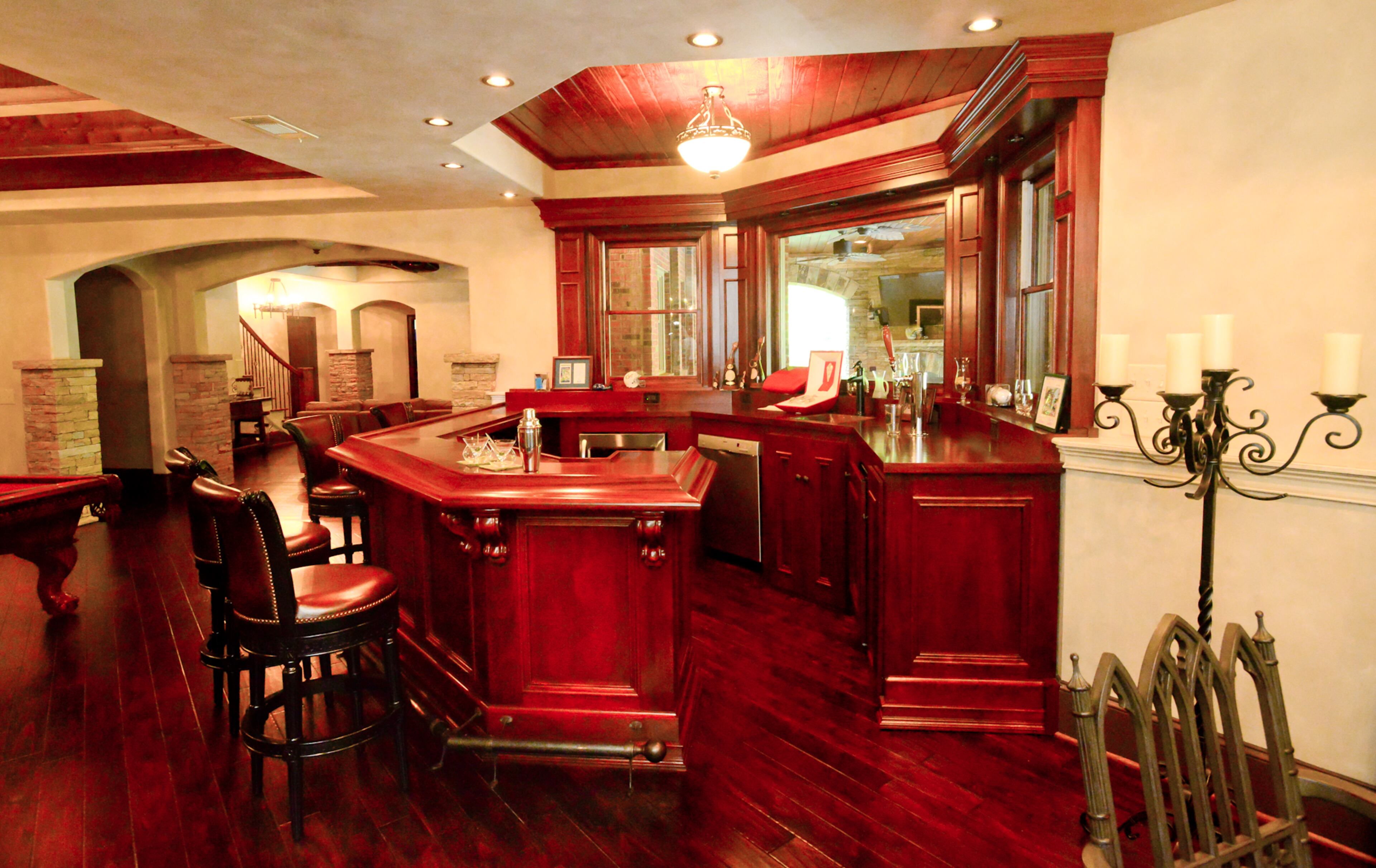 A handcrafted mahogany and brass bar, in the style of an English Pub, and a pool table are in the terrace level. The terrace level was designed to be "old world" meets gothic and has unique touches from iron sconces to an iron chandelier that is an electrified antique.