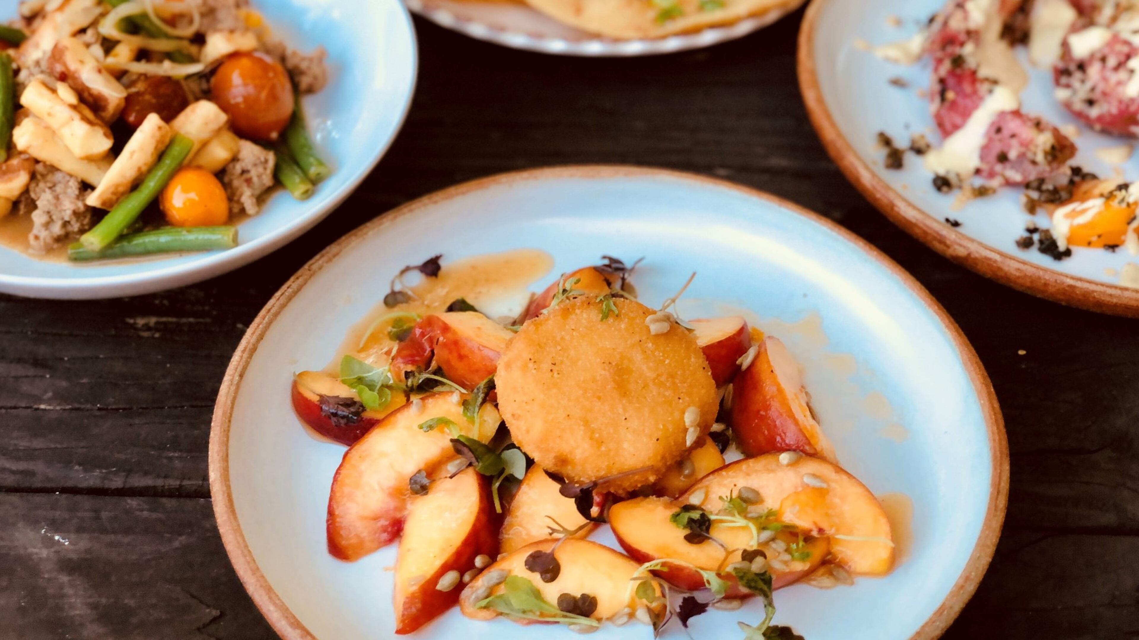 A peach salad with fried brie is a summer stunner at Banshee. In the background: Parisian gnocchi, fry bread and tomato Caesar. CONTRIBUTED BY WENDELL BROCK
