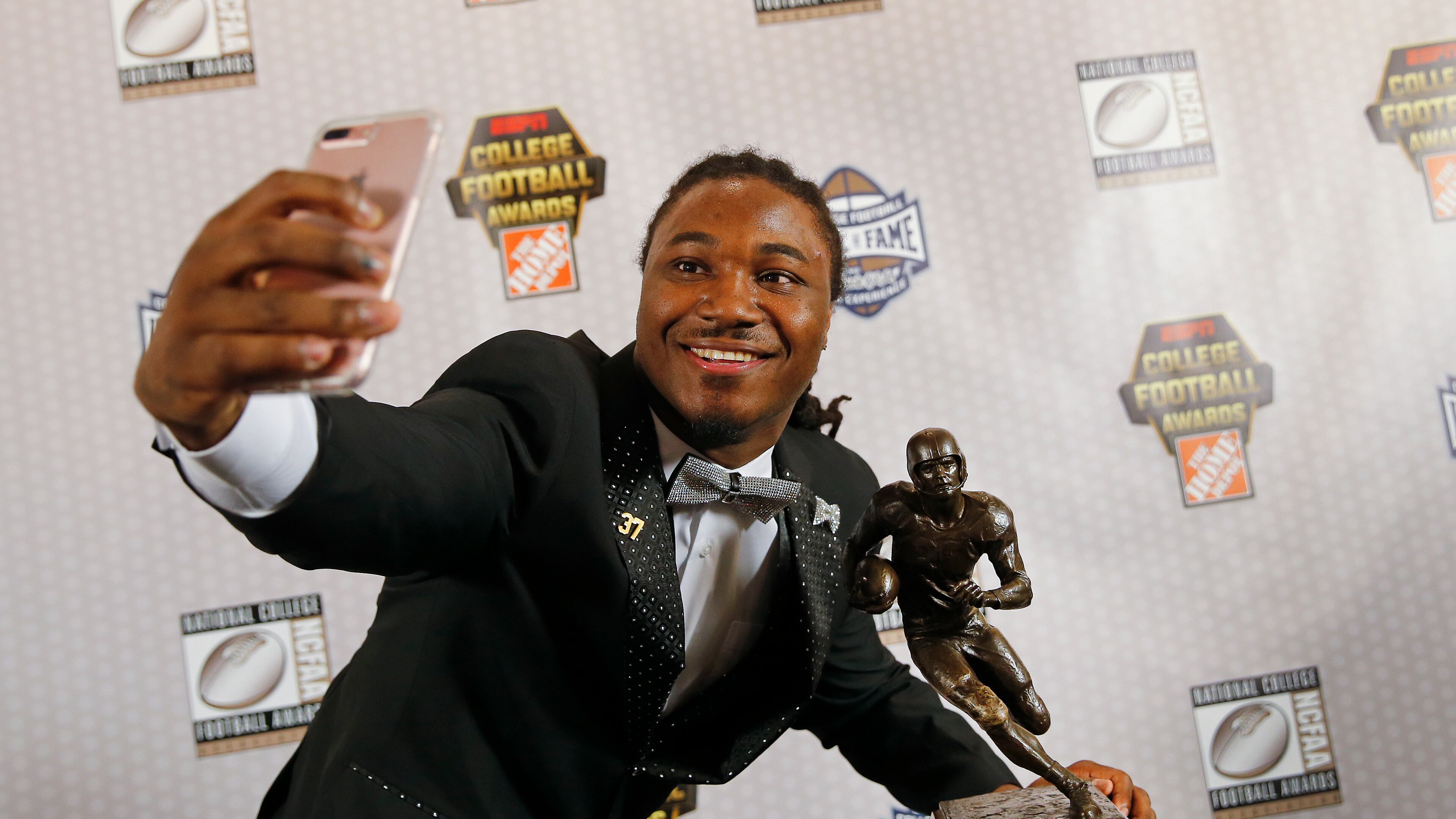 Texas running back D'Onta Foreman takes a selfie with the Doak Walker Award after winning it for being the nation's premier running back Thursday, Dec. 8, 2016, in Atlanta. (AP Photo/John Bazemore)