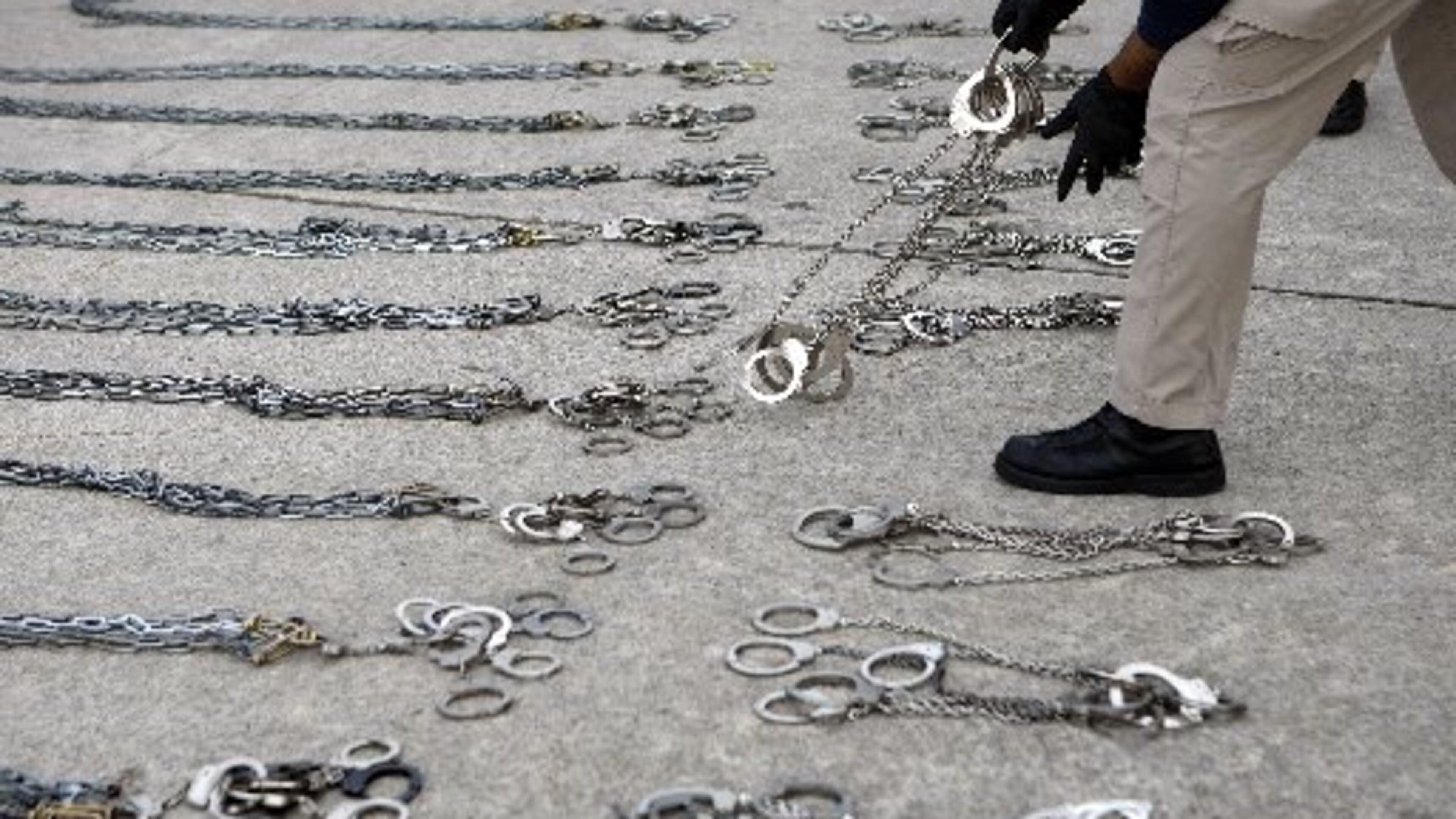 A U.S. Immigration and Customs Enforcement agent prepares shackles to restrain 100 people on a deportation flight out of Atlanta on Thursday, May 3, 2012. Curtis Compton/ccompton@ajc.com
