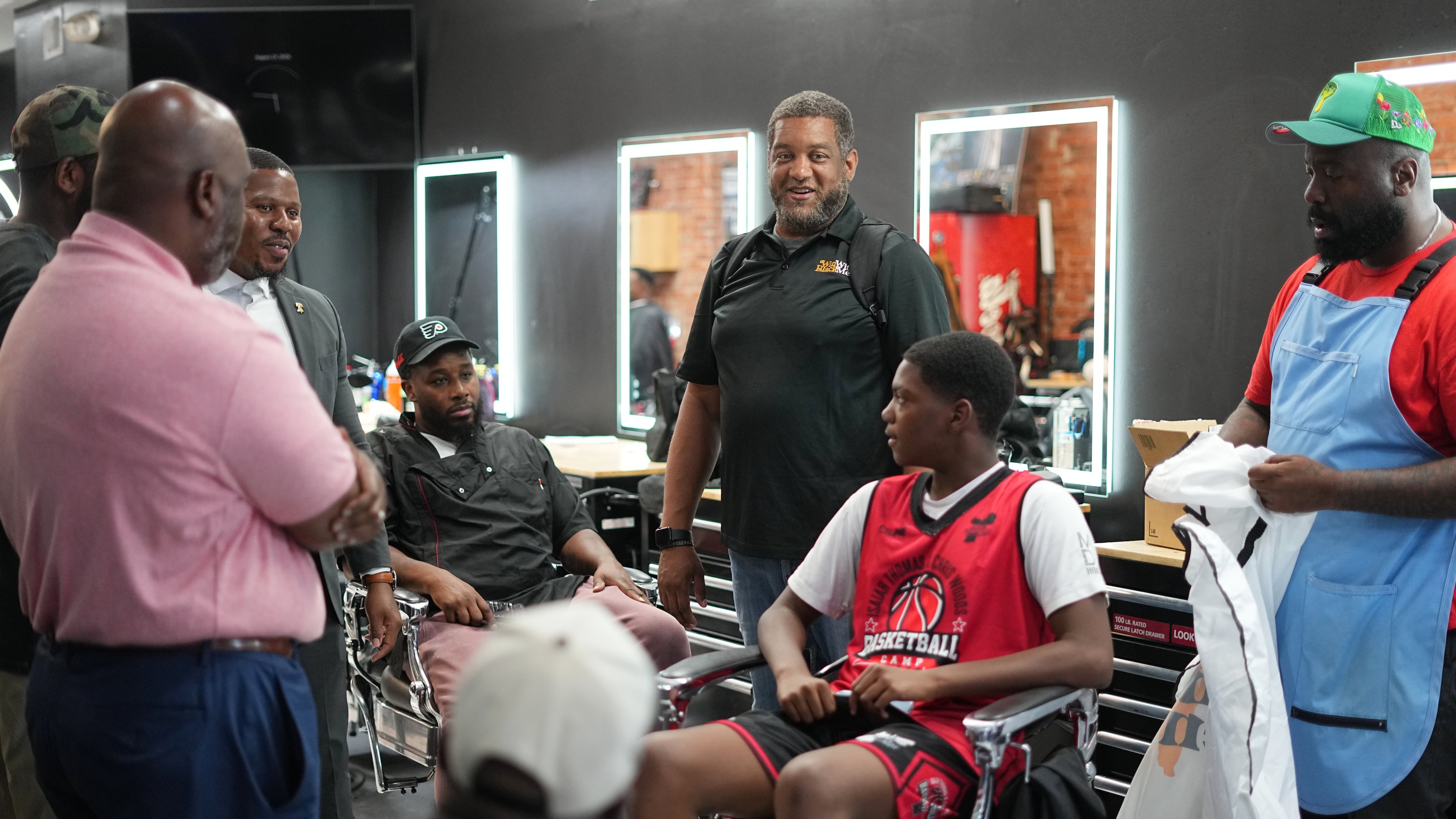 Khalil Thompson, center, co-founder of Win With Black Men, leads a discussion at Philly Cuts barber shop in Philadelphia, Friday, Aug. 21, 2026. (AP Photo/Matt Rourke)