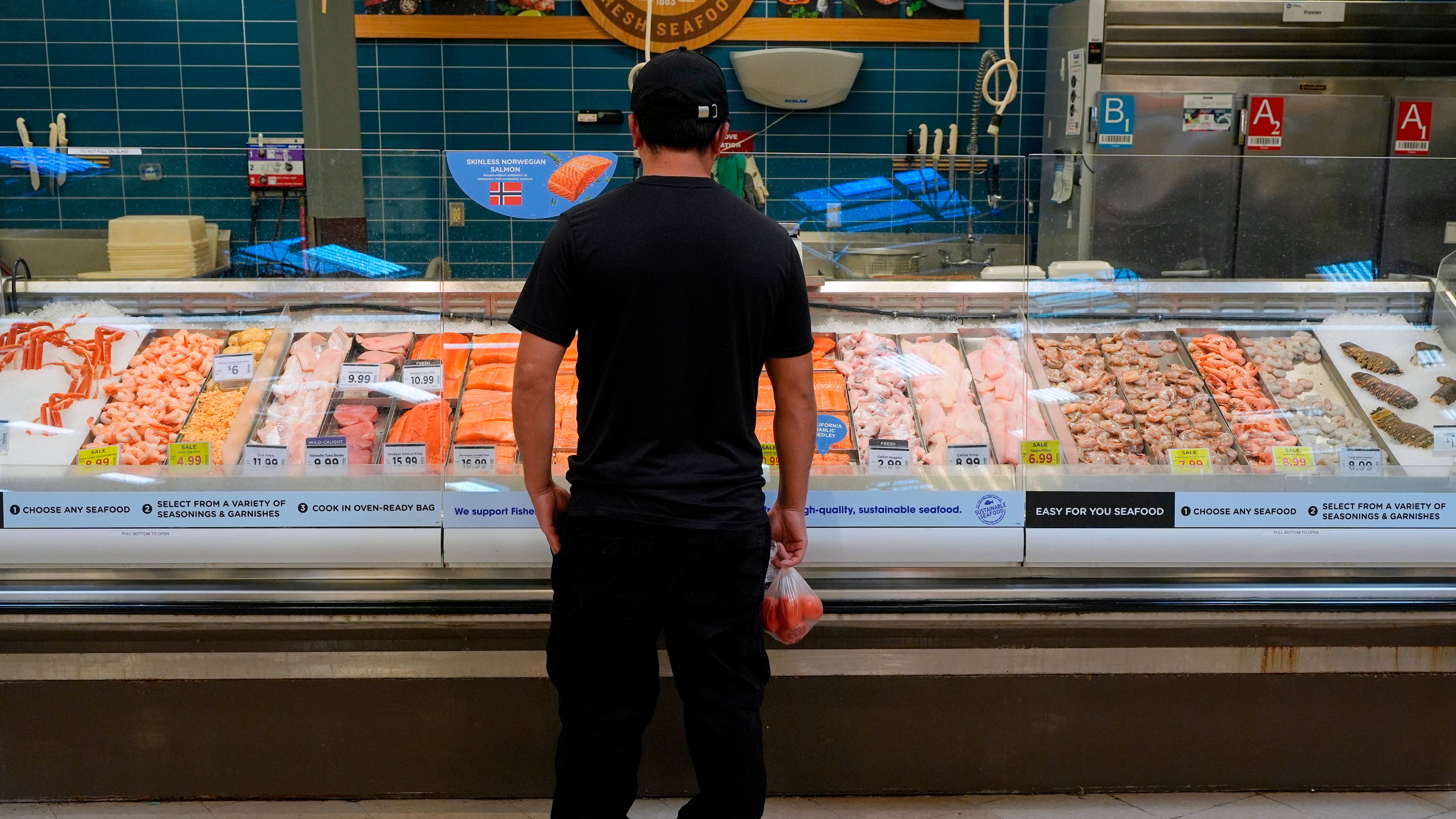 A person looks at the fresh fish at a grocery store Monday, May 11, 2026, in Nashville, Tenn. (AP Photo/George Walker IV)
