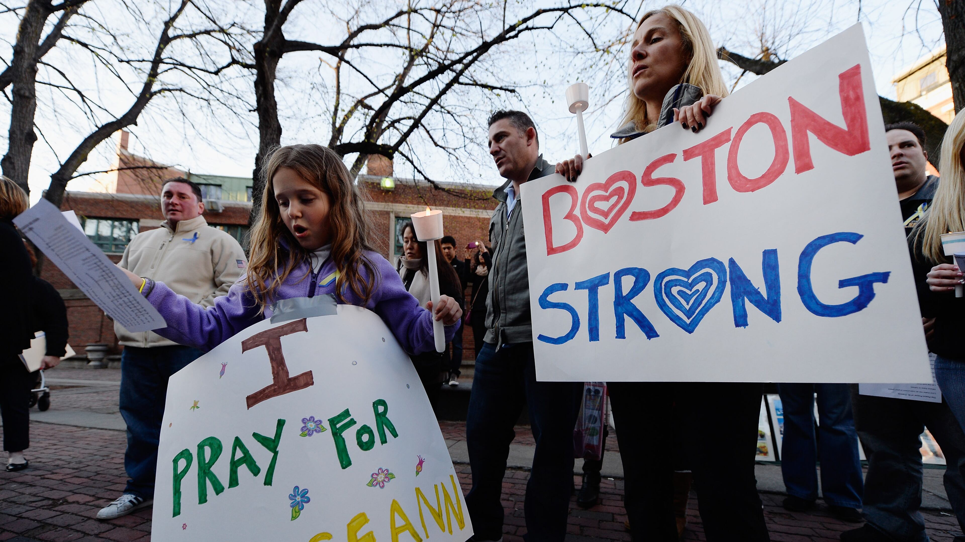 BOSTON, MA - APRIL 21: Adriana Passacantilli, 7, and her mother Sue participate in a candelight vigil for Roseann Sdoia who was seriously injured during the Boston Marathon bombings on April 21, 2013 in Boston, Massachusetts. A manhunt for Dzhokhar A. Tsarnaev, 19, a suspect in the Boston Marathon bombing ended after he was apprehended on a boat parked on a residential property in Watertown, Massachusetts. His brother Tamerlan Tsarnaev, 26, the other suspect, was shot and killed after a car chase and shootout with police. The bombing, on April 15 at the finish line of the marathon, killed three people and wounded at least 170. (Photo by Kevork Djansezian/Getty Images)