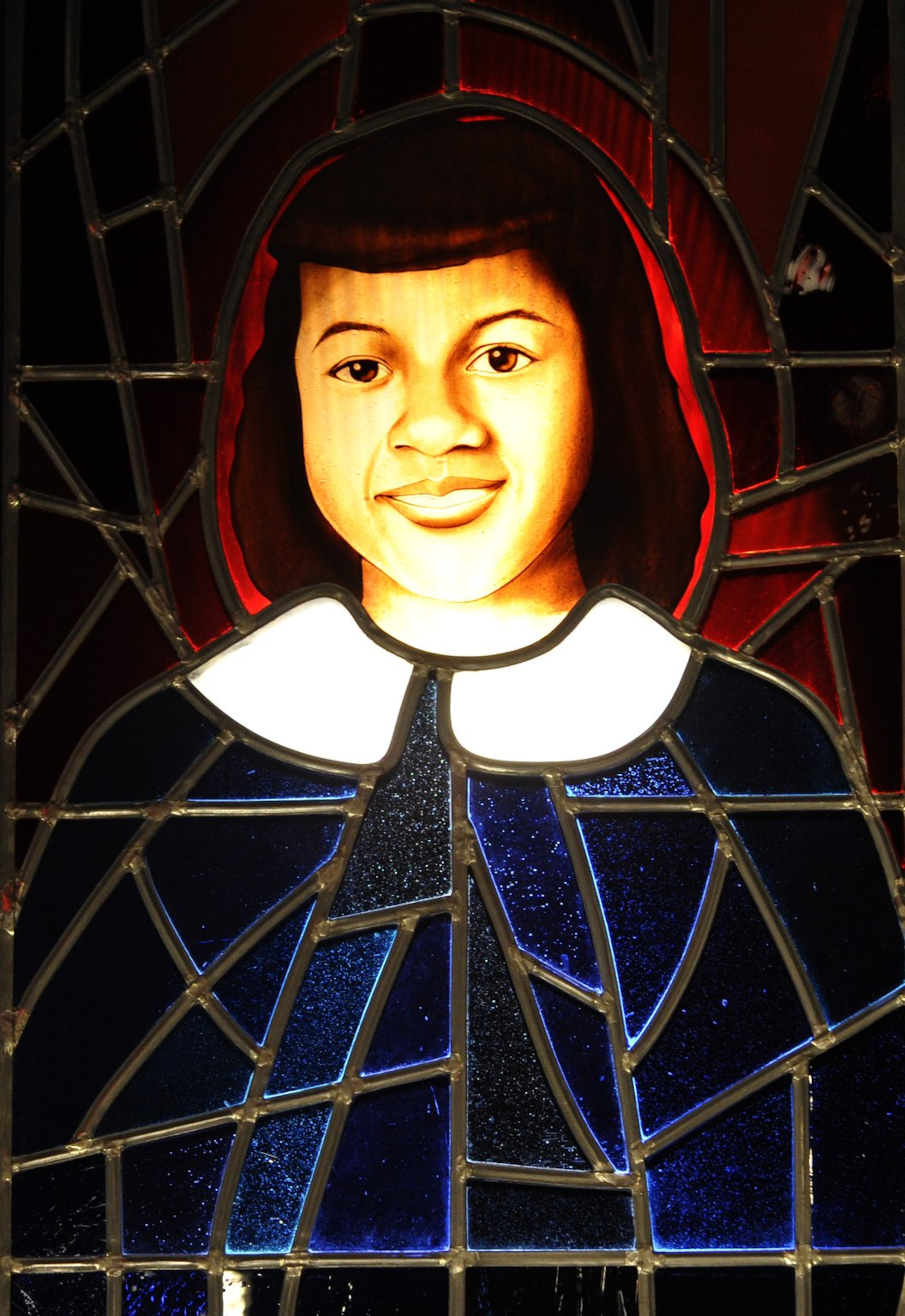 A stained-glass portrait of Cynthia Wesley, one of the four young girls killed in the Birmingham church bombing of 1963, hangs at the National Center for Civil and Human Rights in Atlanta. CONTRIBUTED BY DAVID TULIS / AJC SPECIAL