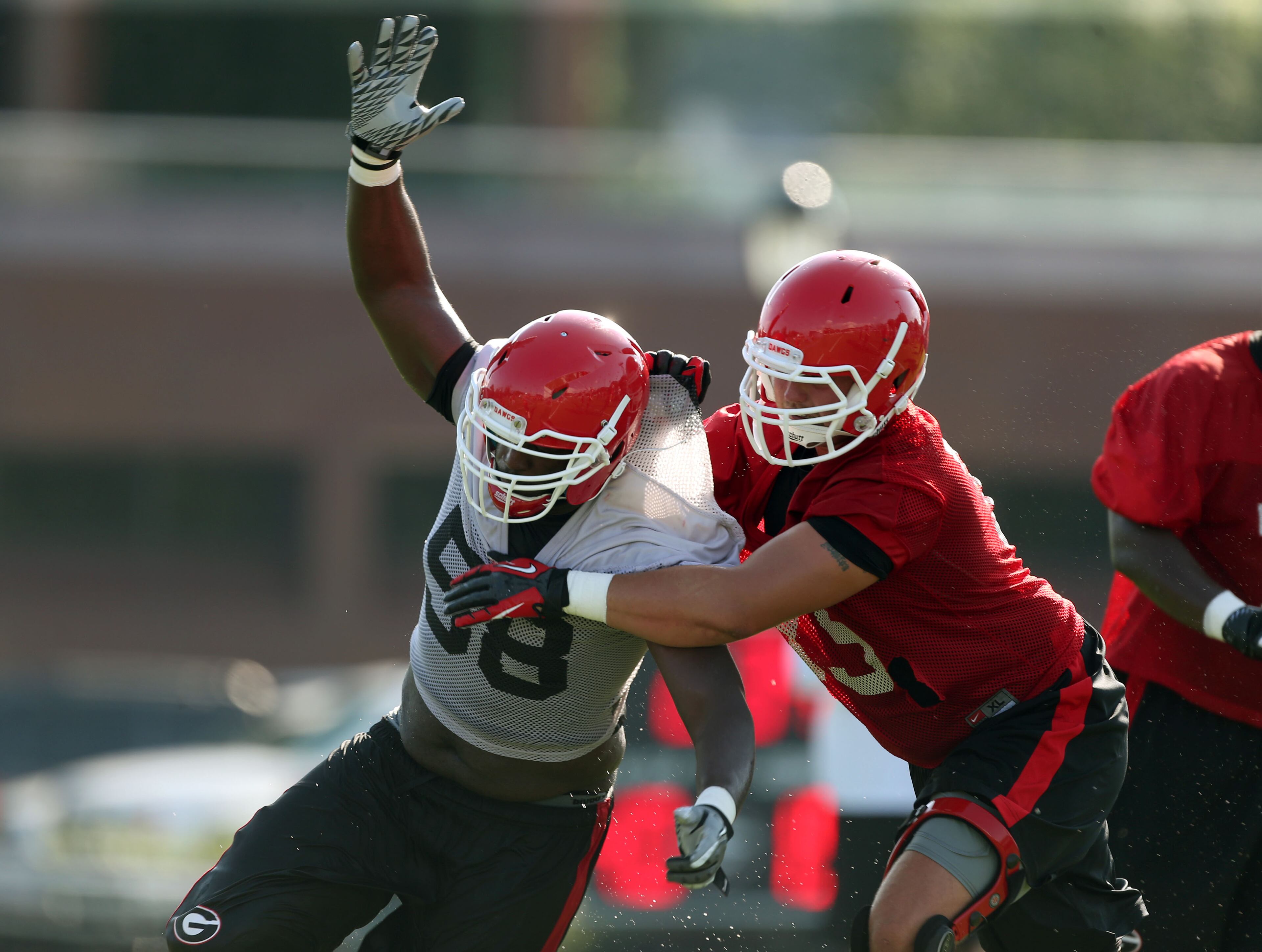University of Georgia offensive lineman Kolton Houston (75, right) attempts to block University of Georgia defensive end Sterling Bailey (58). JASON GETZ / JGETZ@AJC.COM