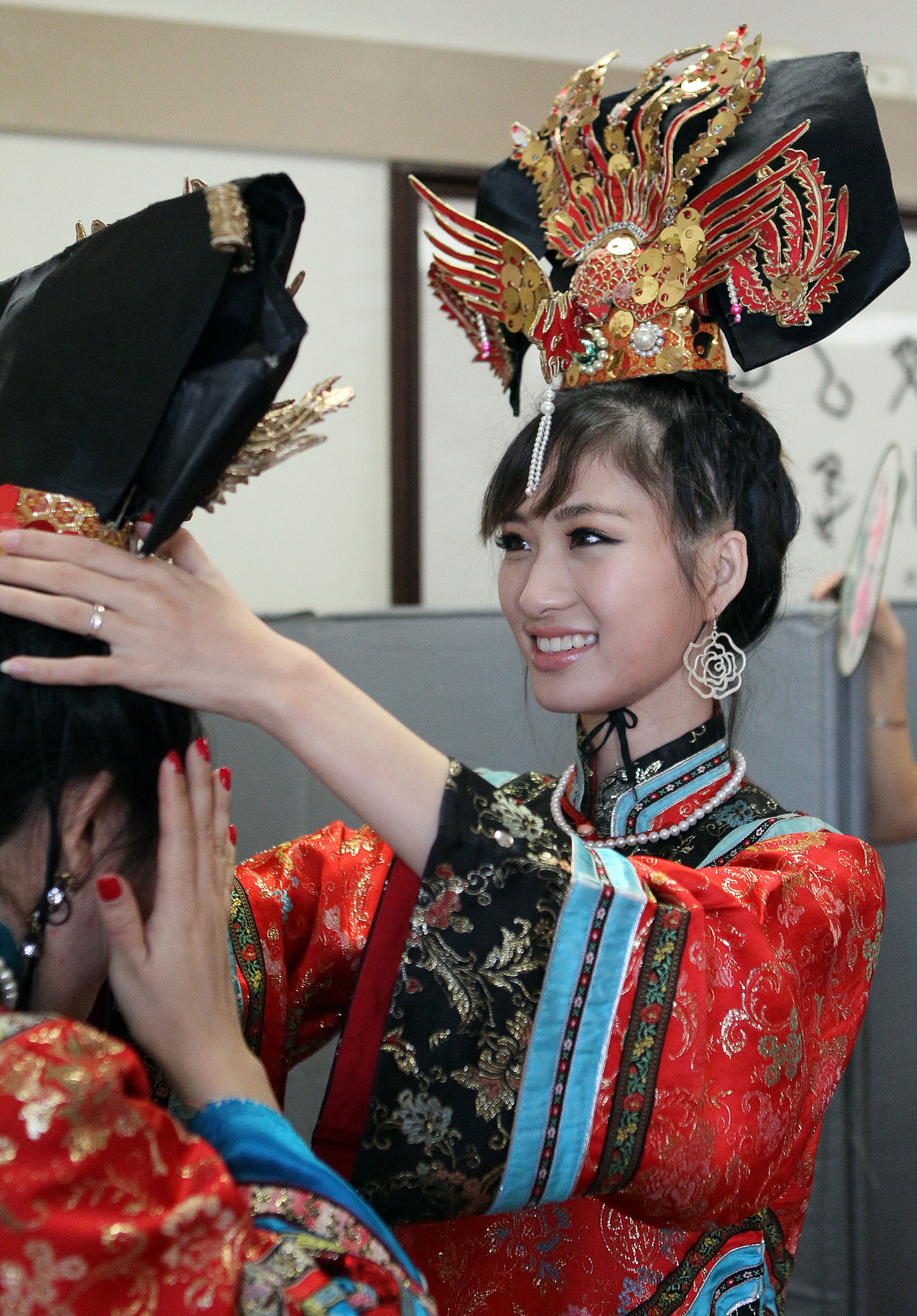 Jenae Jia (right) helps Veve Chen with her traditional costume at the Atlanta Chinese Culture Center in Chamblee Saturday Feb. 9, 2013.