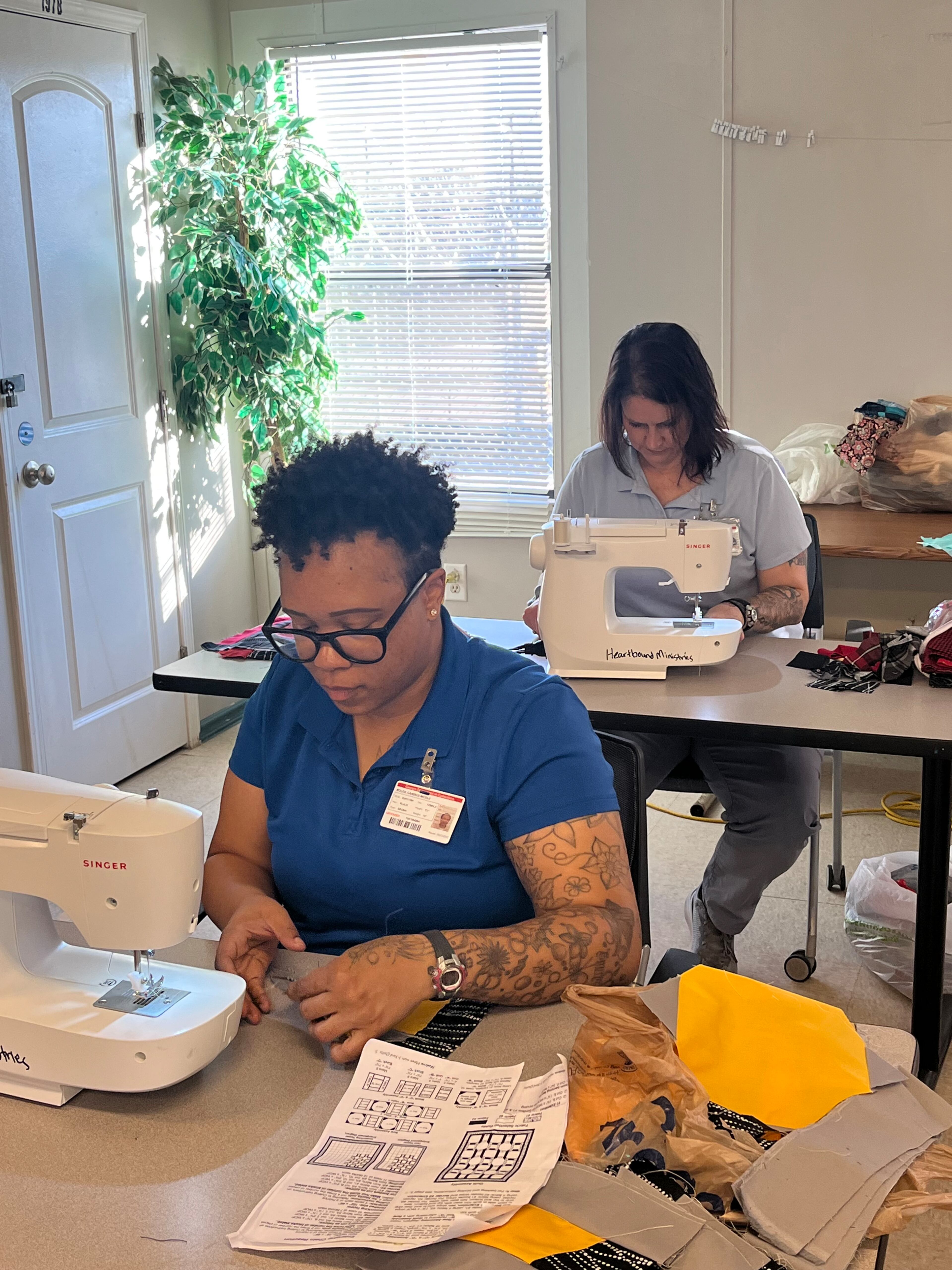 Candice Boles sews quilt blocks together in quilting class at the Women's Transition Center in South DeKalb County. Behind her Shannon Waters works on her own project
(Courtesy HeartBound Ministries)