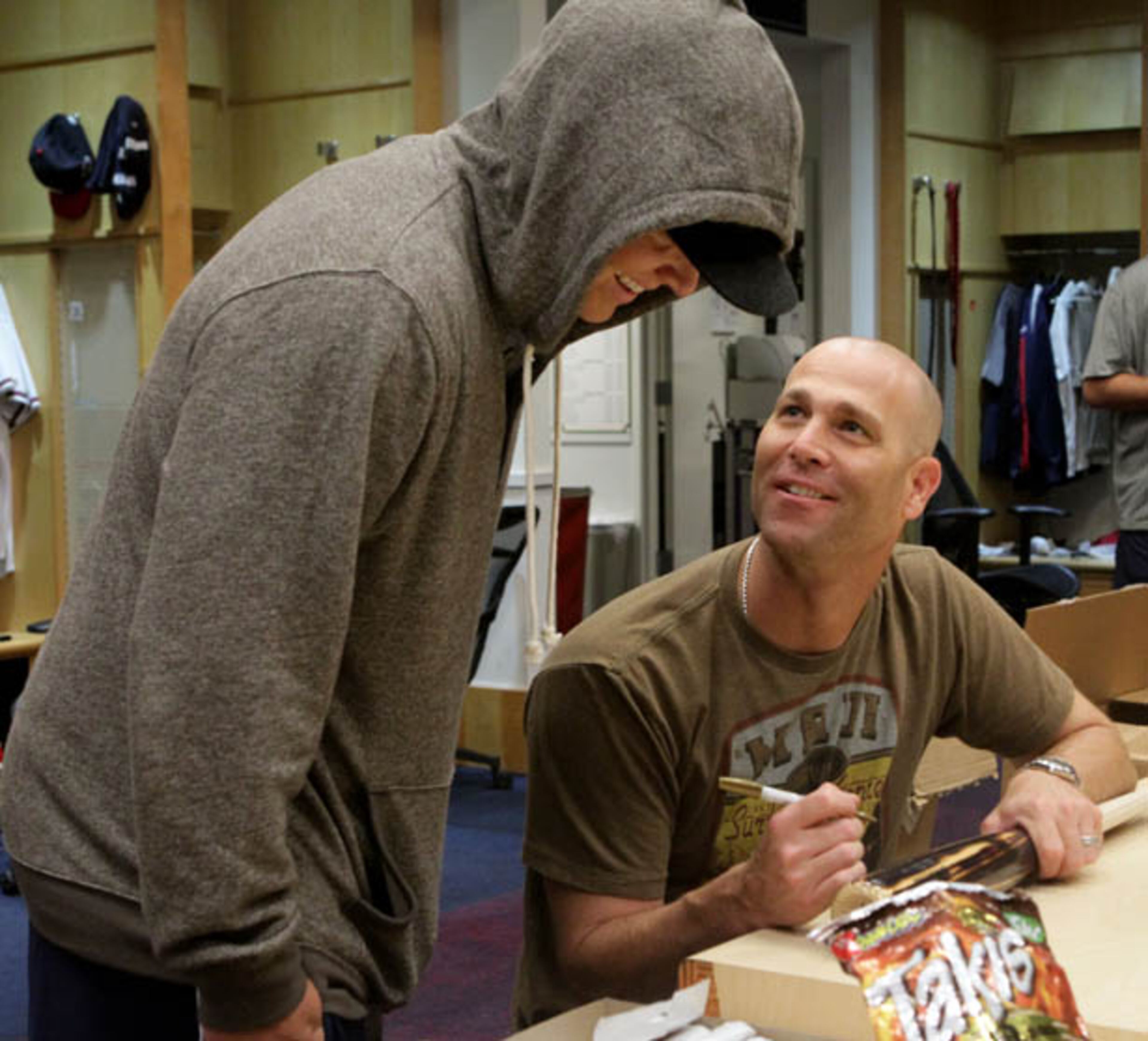 Braves pitchers Kris Medlen (left) and Tim Hudson chat as Hudson signs items in the Braves clubhouse.
