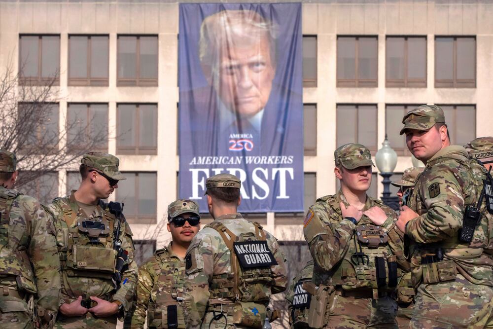 National Guard members gather near a large portrait of President Donald Trump on the Labor Department headquarters in Washington in January. (Mark Schiefelbein/AP)