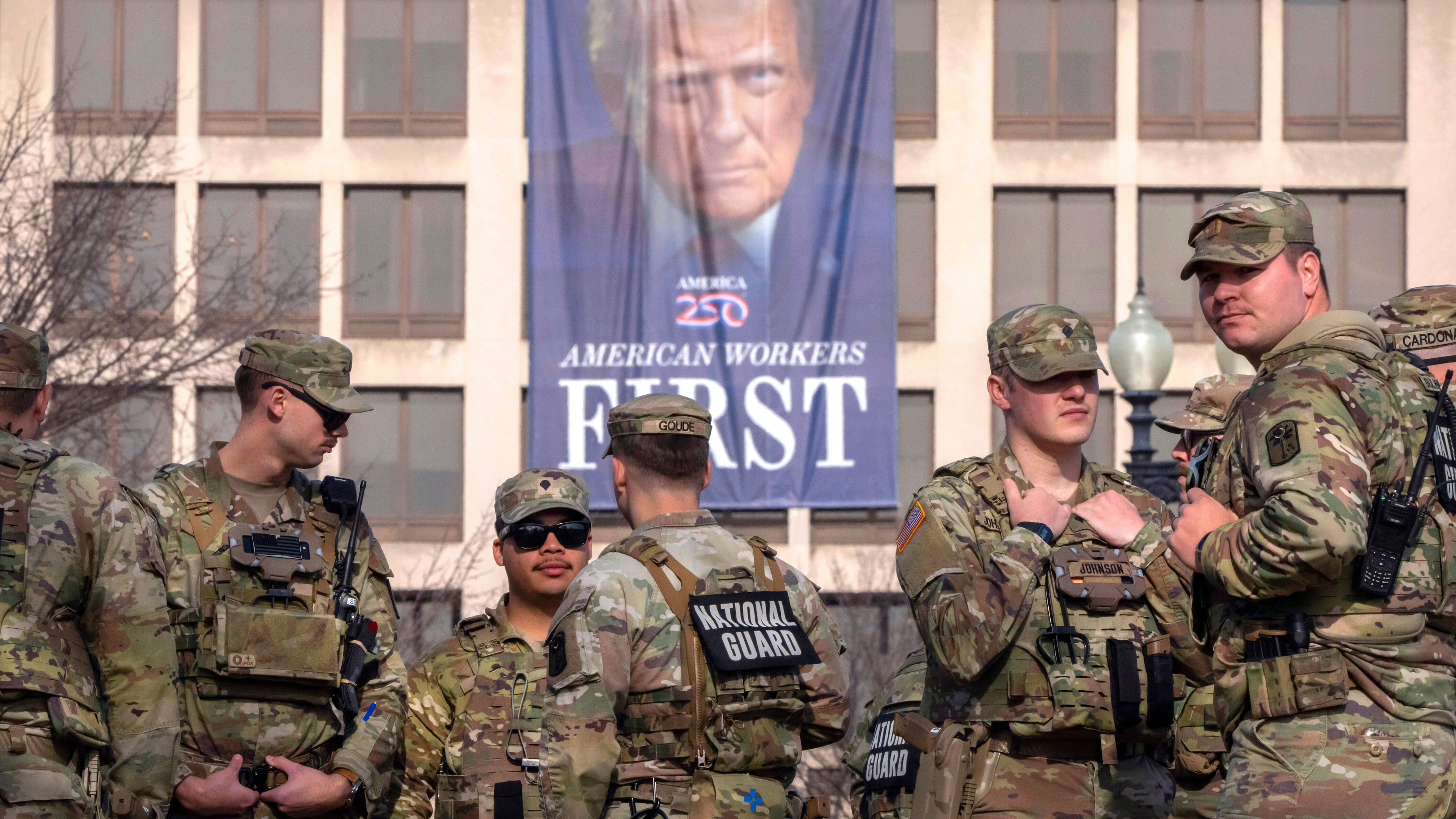 FILE - National Guard members gather near a large portrait of President Donald Trump on the Labor Department headquarters before the body of Metropolitan Police Department officer Terry Bennett is driven past the Capitol, Jan. 8, 2026, in Washington. (AP Photo/Mark Schiefelbein, File)