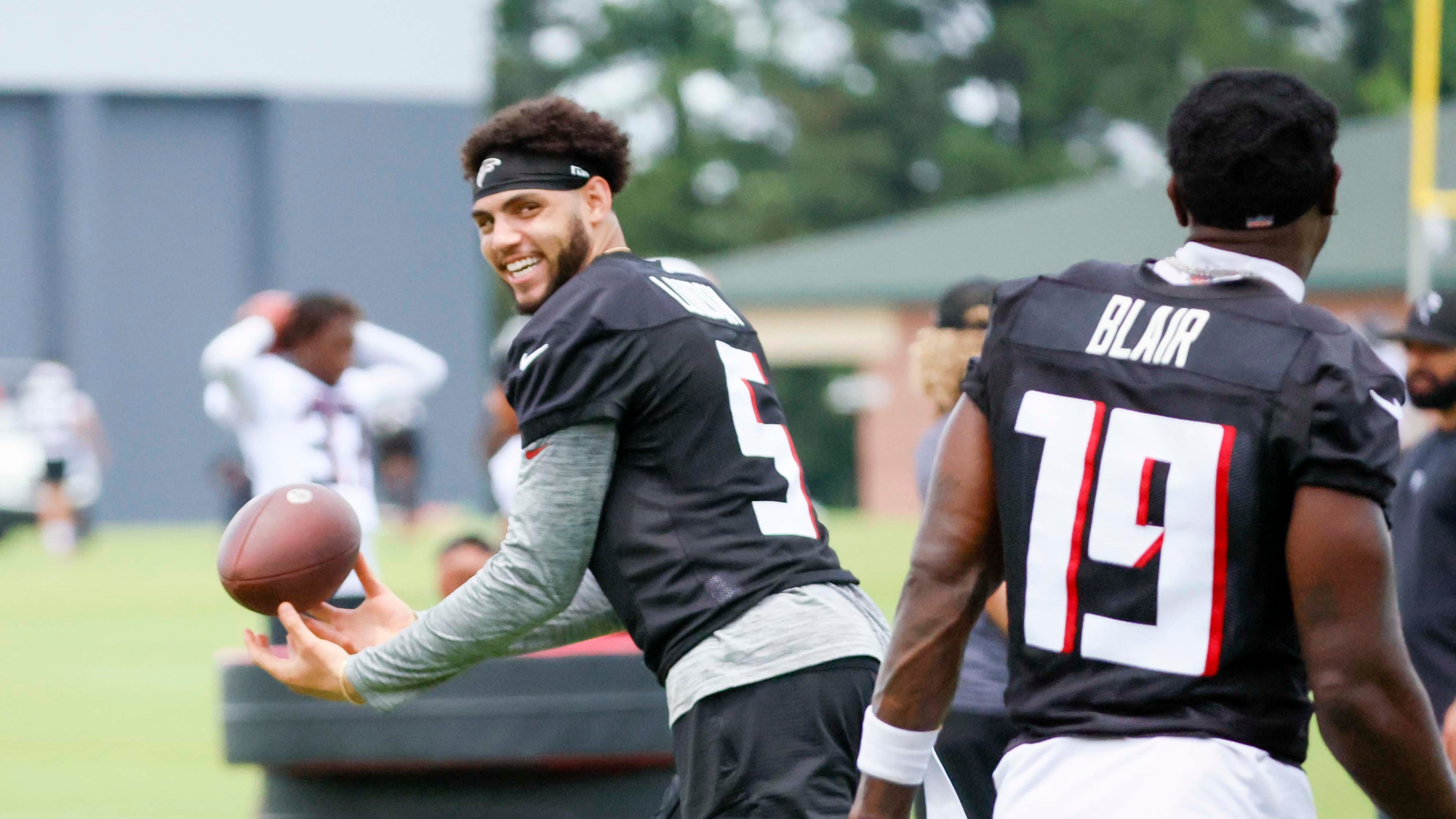Atlanta Falcons wide receiver Drake London smiles with wide receiver Chris Blair while maneuvering the ball during minicamp at the team's training facility on Wednesday, June 11, 2025, in Flowery Branch, Ga. (Miguel Martinez/AJC)