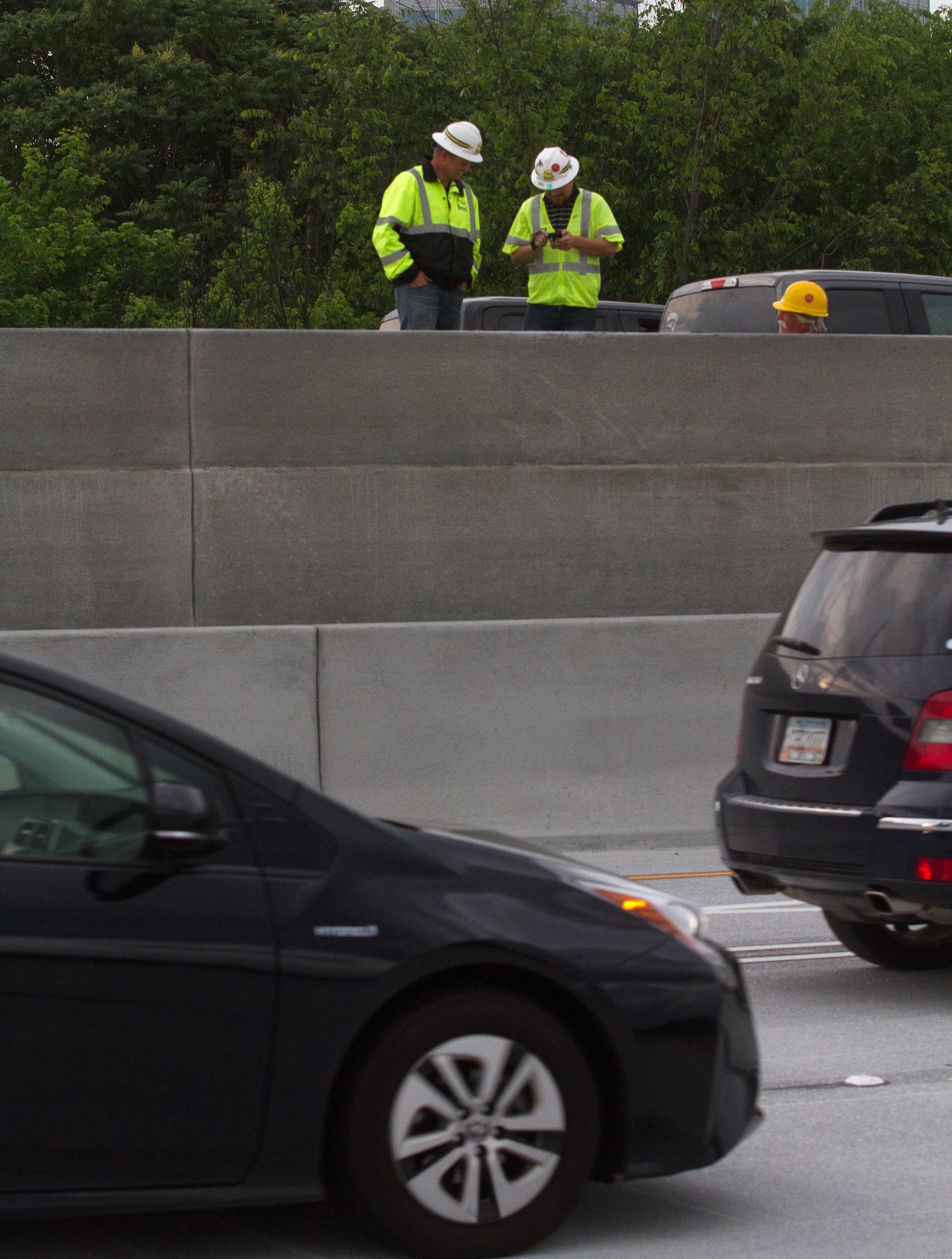 Workers work on the sound bound lanes of I-85 as cars drive over the newly opened northbound lanes Friday evening in Atlanta GA. May 12, 2017. STEVE SCHAEFER / SPECIAL TO THE AJC