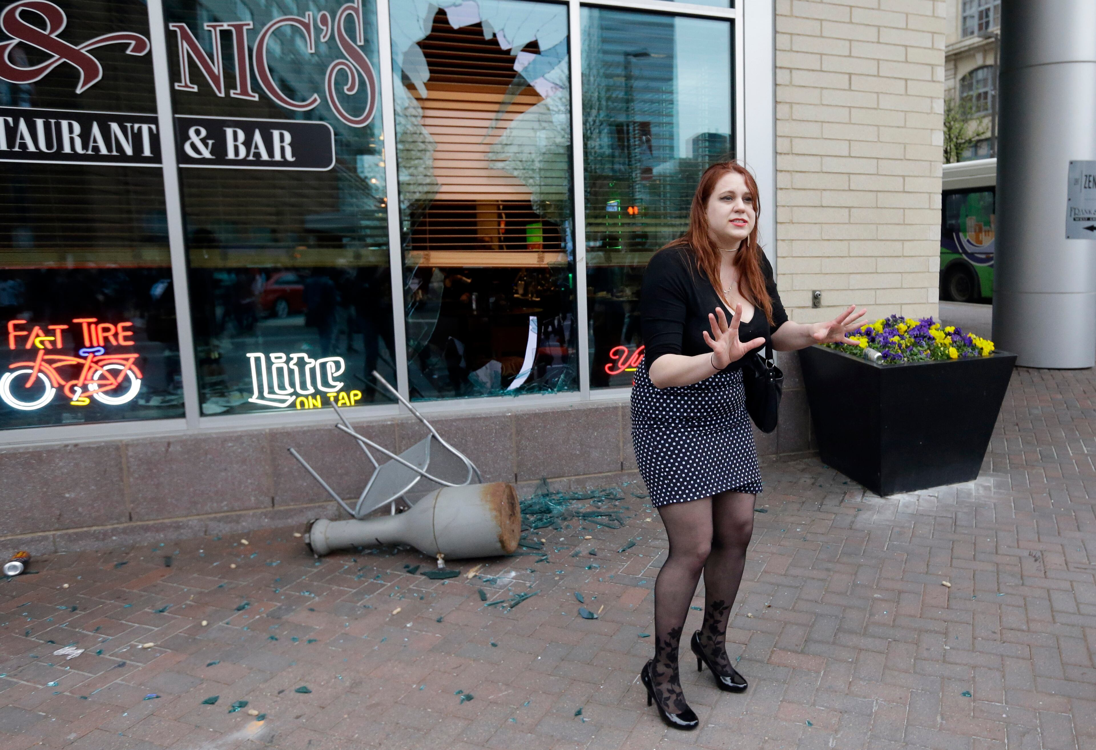 A woman pleads with protestors to stop breaking restaurant windows after a rally for Freddie Gray, Saturday, April 25, 2015, in Baltimore. Gray died from spinal injuries about a week after he was arrested and transported in a police van. (AP Photo/Patrick Semansky)