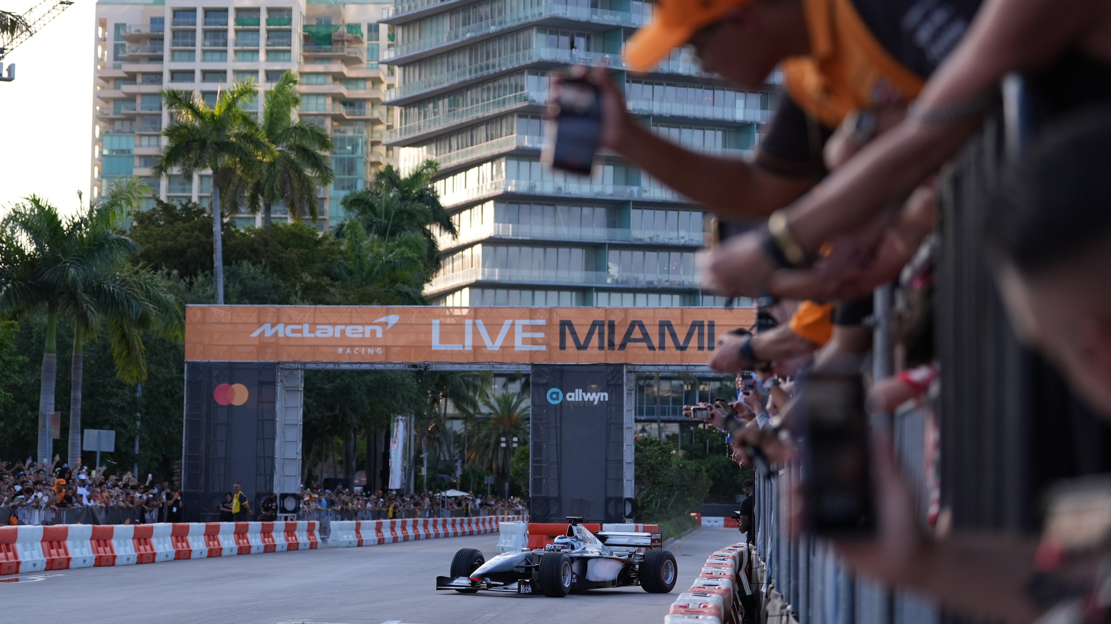 Fans watch as former Brazilian racing driver Bruno Senna steers an MP4/6 during a fan event showcasing past McLaren race cars ahead of the Formula One Miami Grand Prix auto race, Wednesday, April 29, 2026, in the Coconut Grove area of Miami. (AP Photo/Rebecca Blackwell)