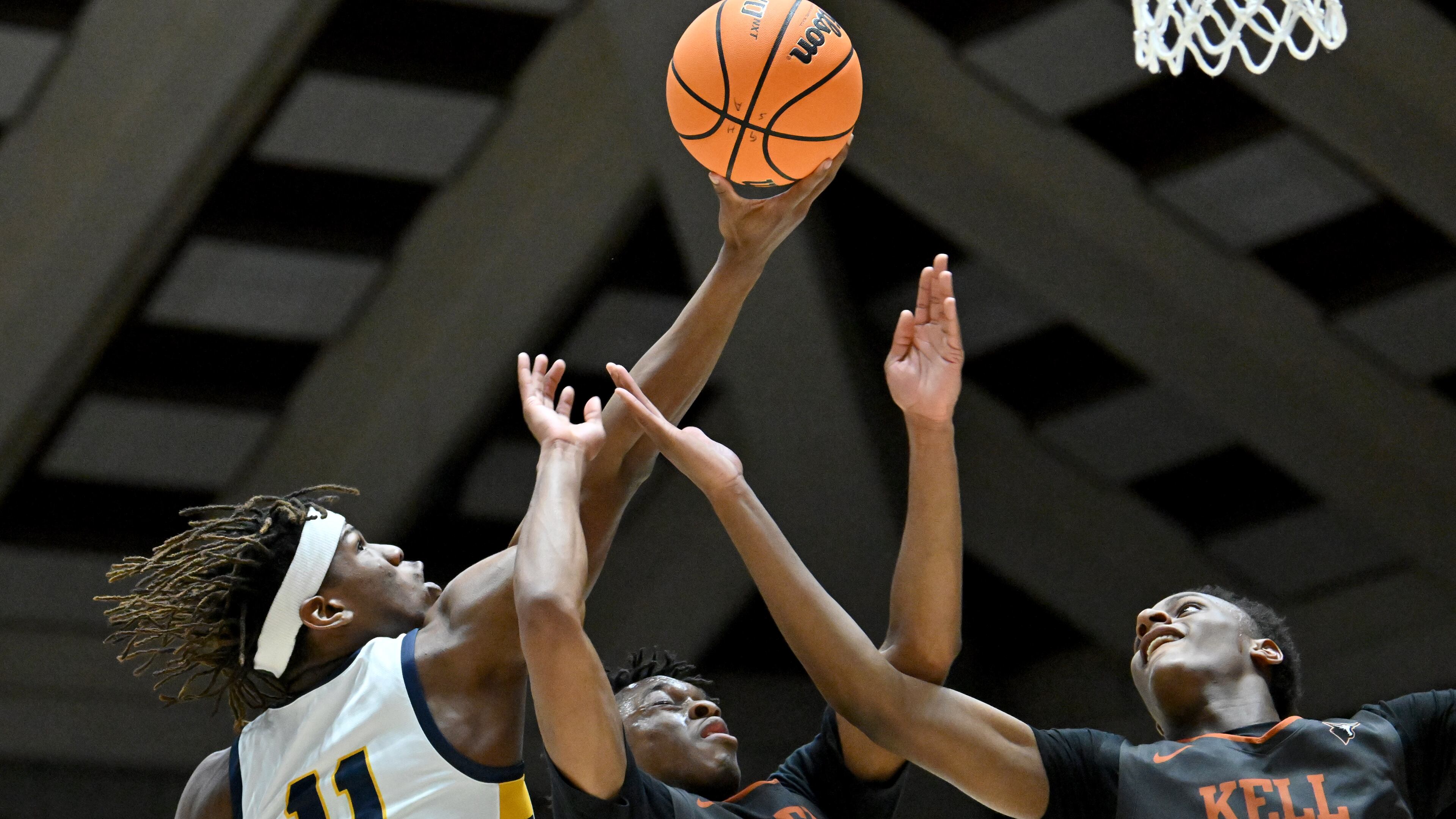 Eagle’s Landing's Chris Morris (11) grabs a rebound over Kell’s CJ Brown (12) and Kell’s Cannon Richards (14) during the first half of GHSA Basketball Class 5A Boy’s State Championship game at the Macon Centreplex, Thursday, Mar. 7, 2024, in Macon. (Hyosub Shin / Hyosub.Shin@ajc.com)