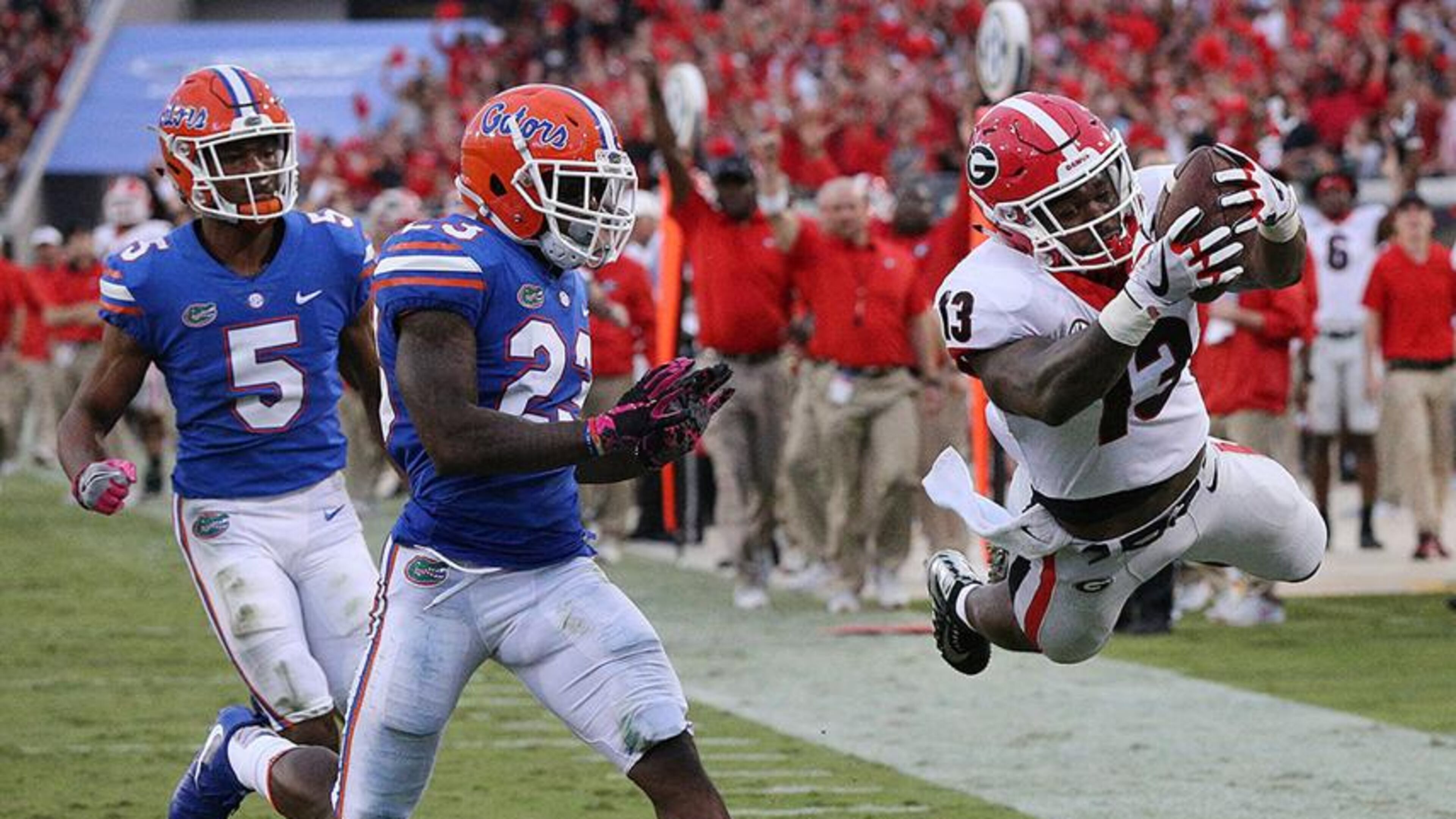 Georgia tailback Elijah Holyfield soars into the end zone past Florida defenders C.J. Henderson and Chauncey Gardner Jr. to take a 42-0 lead during the fourth quarter in the Georgia-Florida game in Jacksonville in 2017. Georgia beat Florida 42-7. Curtis Compton/ccompton@ajc.com