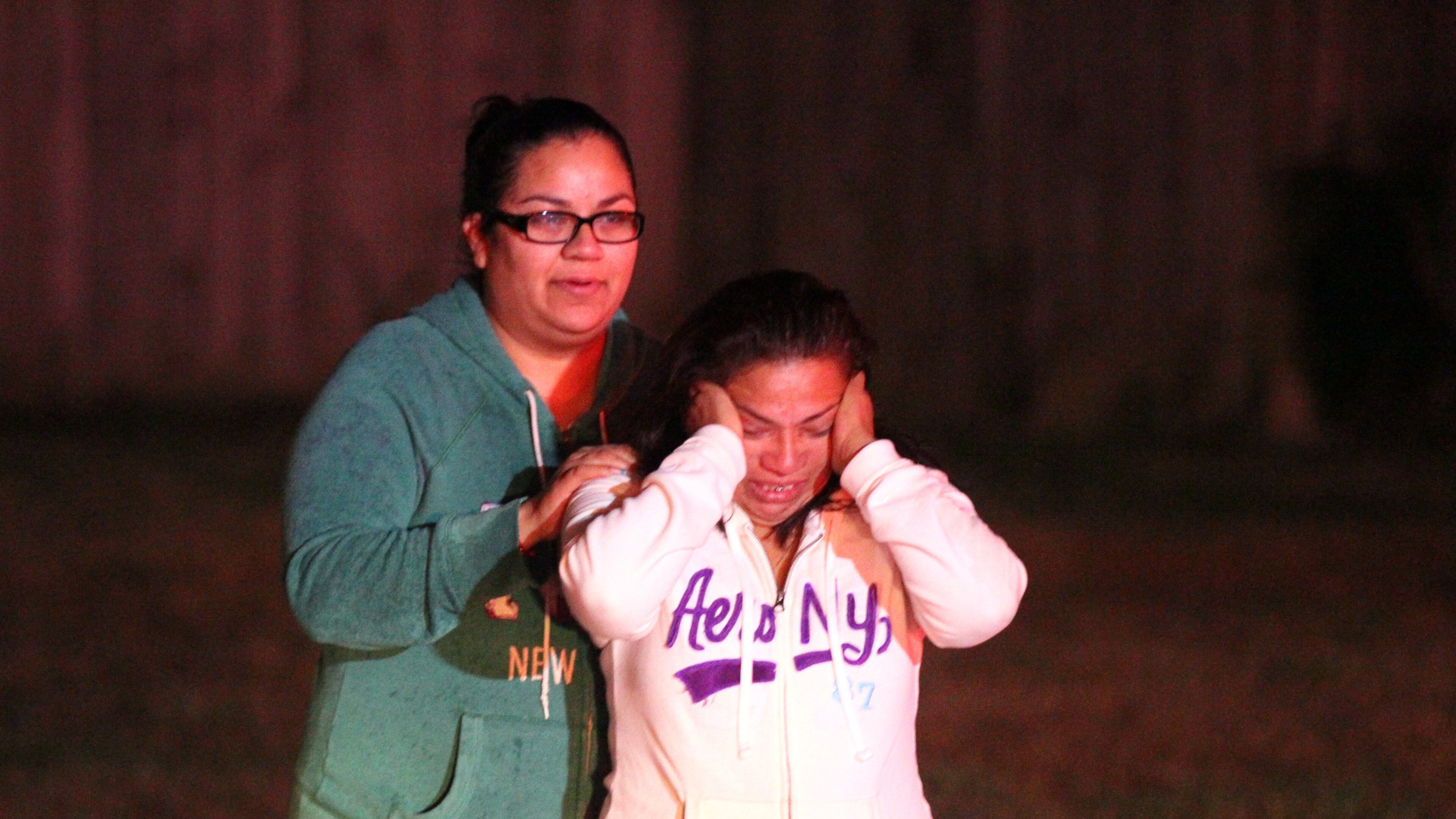 From left, Yesica Andrade comforts her mother Ruth Perez after she escaped serious injury in a predawn fire Friday by jumping from the second-floor deck of her burning home. Perez was asleep when the fire broke out in her home in the 1600 block of Black Hickory Place near Norcross.