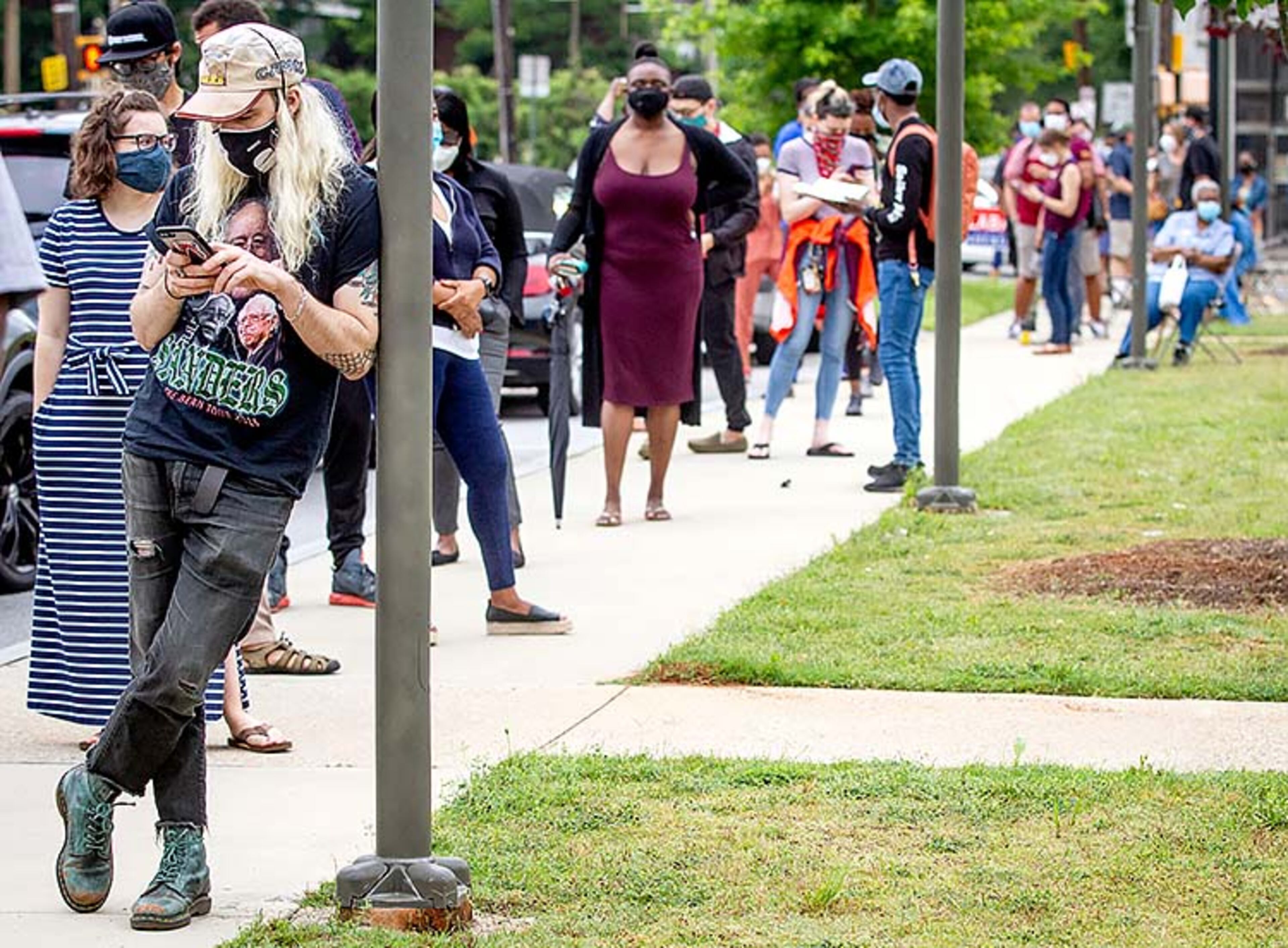 Caleb Davis (L) catches up on his reading as he waits in a long voting line at the Metropolitan Library Tuesday, June 9, 2020. STEVE SCHAEFER FOR THE ATLANTA JOURNAL-CONSTITUTION