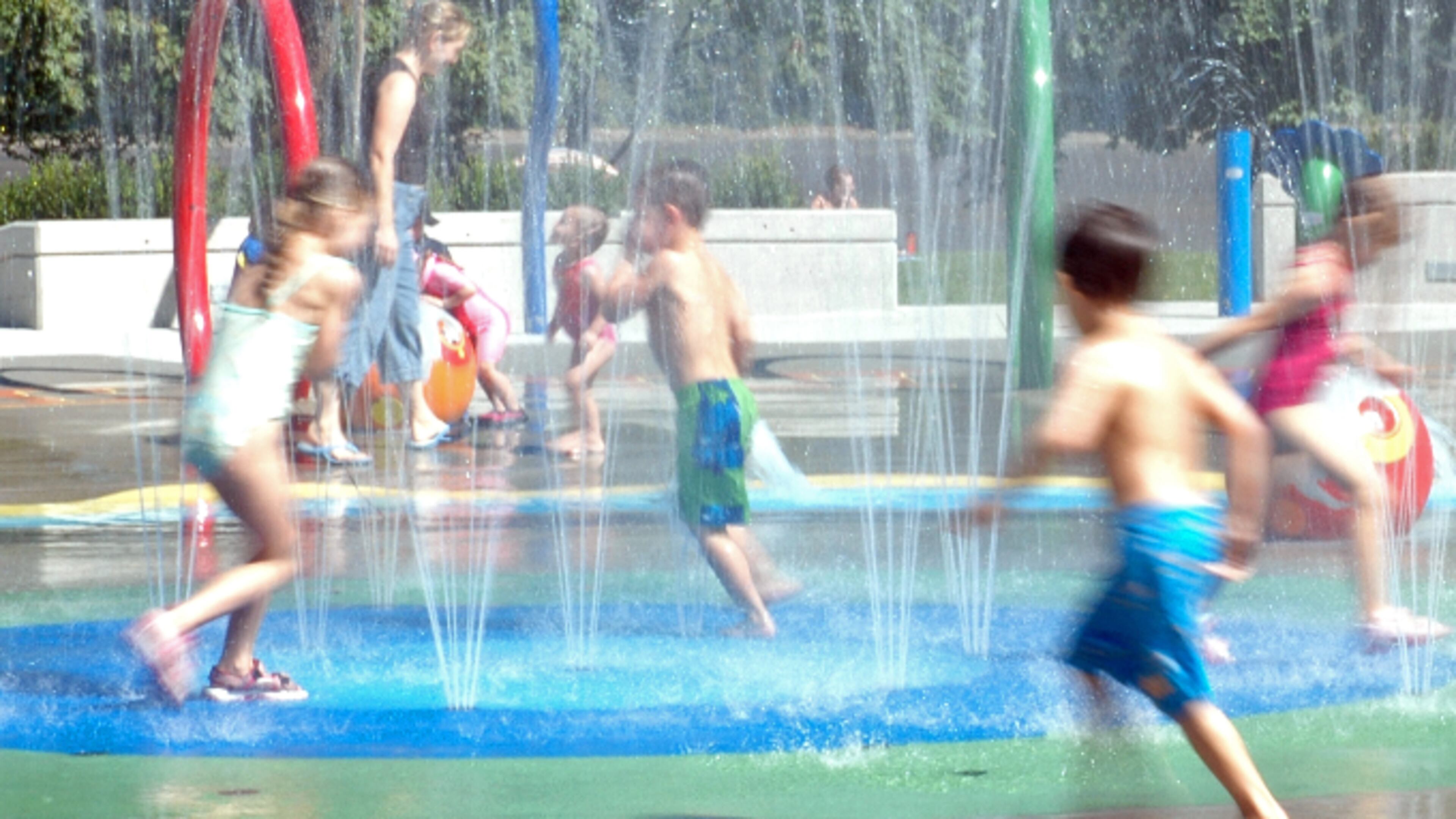 Kids playing in fountain (stock photo).