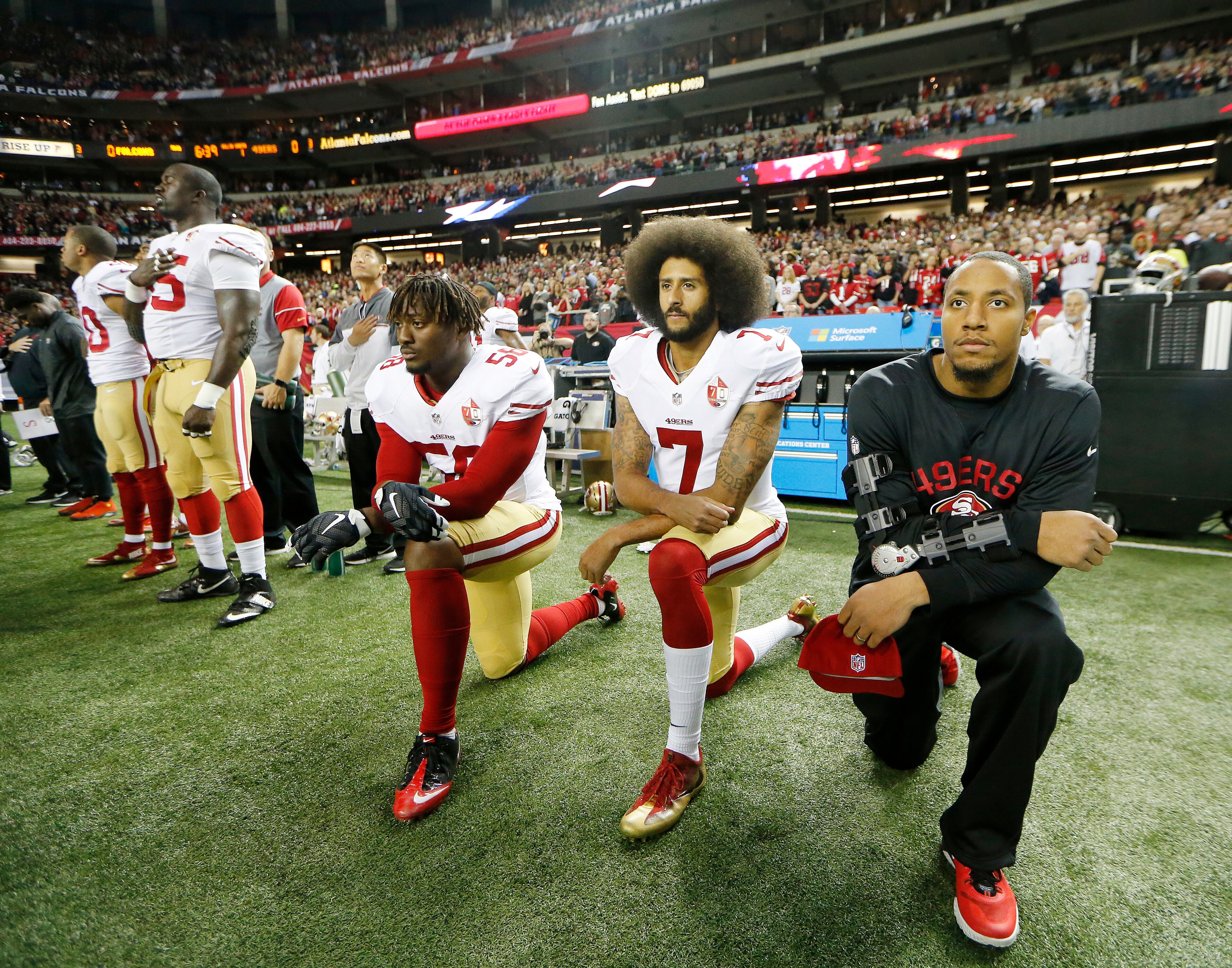 San Francisco 49ers quarterback Colin Kaepernick (7) and San Francisco 49ers outside linebacker Eli Harold (58) kneel during the playing of the National anthem before the first half of an NFL football game between the Atlanta Falcons and the San Francisco 49ers, Sunday, Dec. 18, 2016, in Atlanta. (AP Photo/John Bazemore)