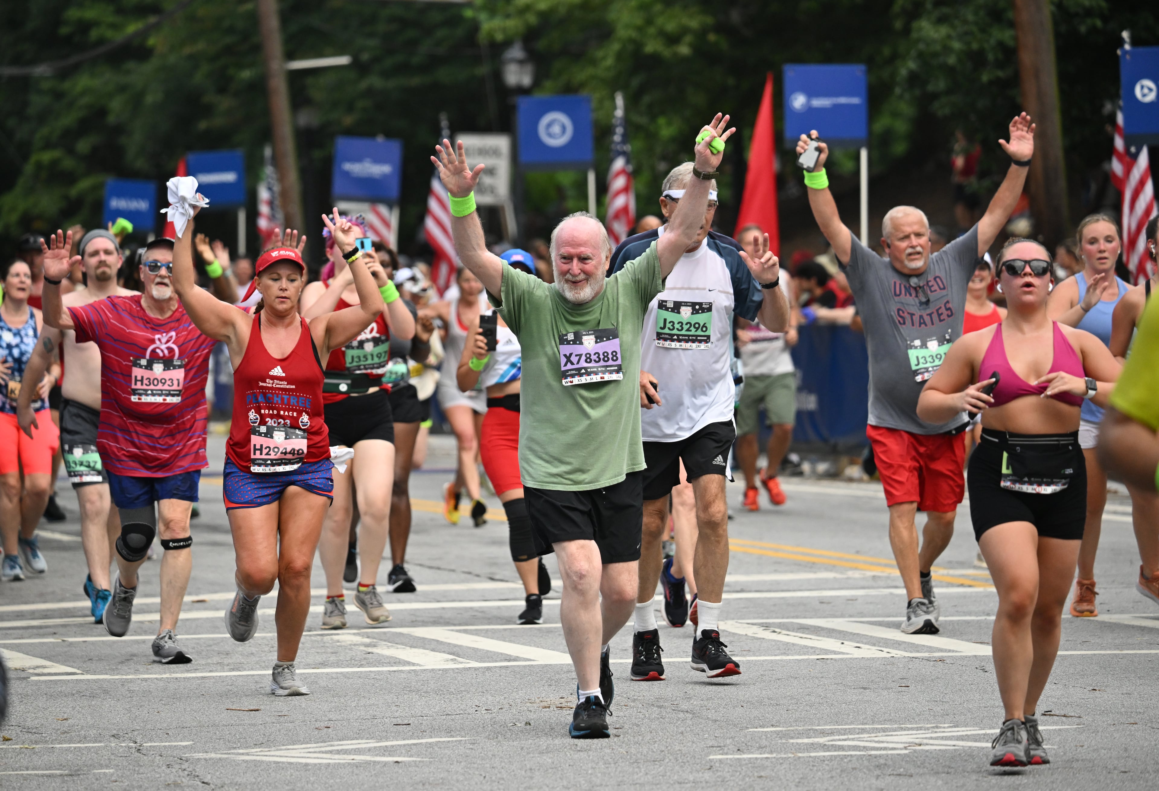 Runners celebrate as they cross the finish line of the 54th running of the Atlanta Journal-Constitution Peachtree Road Race during the 2023 Atlanta Journal-Constitution Peachtree Road Race, Tuesday, July 4, 2023, in Atlanta. (Hyosub Shin / Hyosub.Shin@ajc.com)