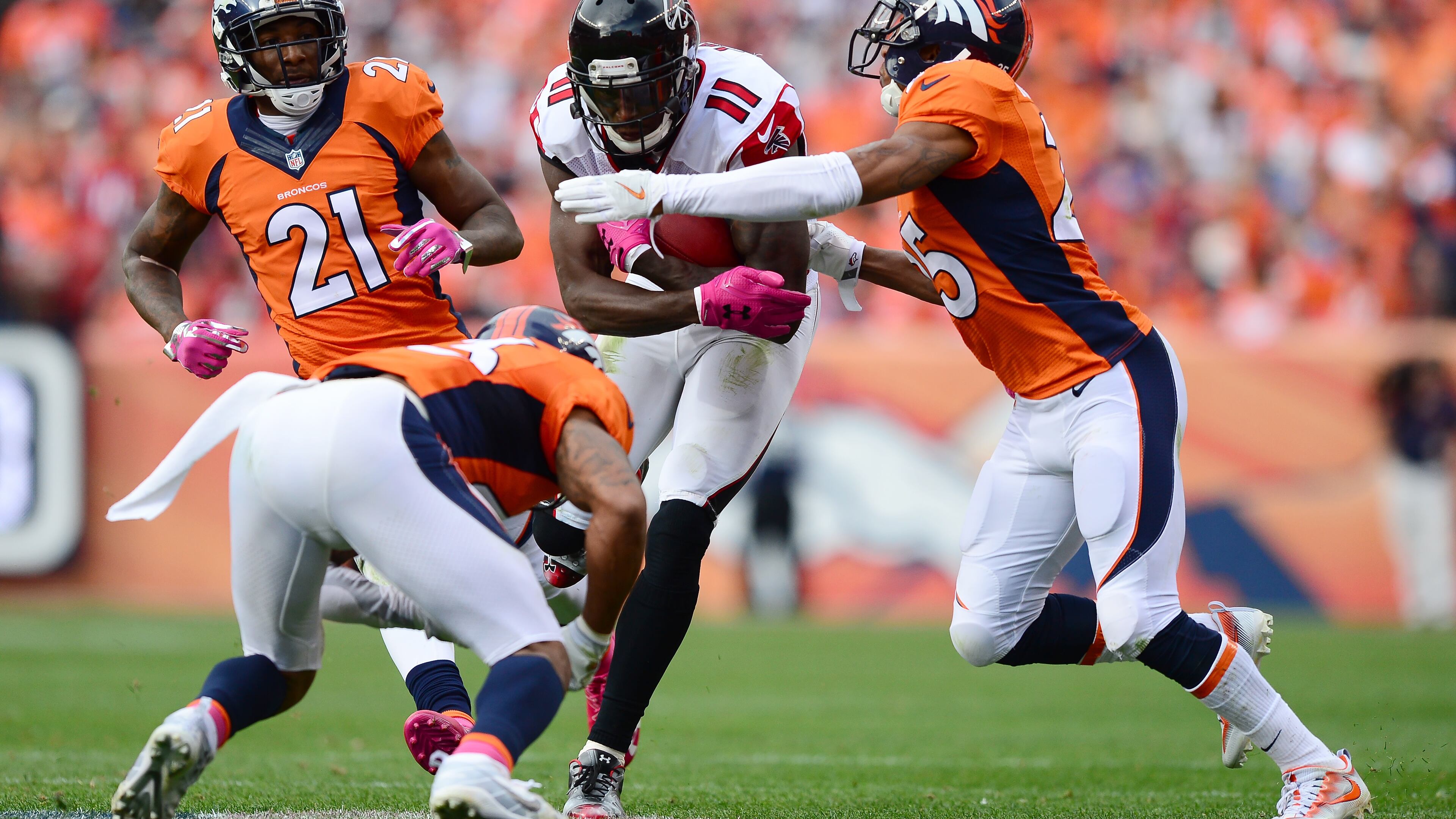 DENVER, CO - OCTOBER 9: Cornerback Chris Harris #25 and strong safety T.J. Ward #43 of the Denver Broncos tackle wide receiver Julio Jones #11 of the Atlanta Falcons after he got a first down in the third quarter of the game at Sports Authority Field at Mile High on October 9, 2016 in Denver, Colorado. (Photo by Dustin Bradford/Getty Images)