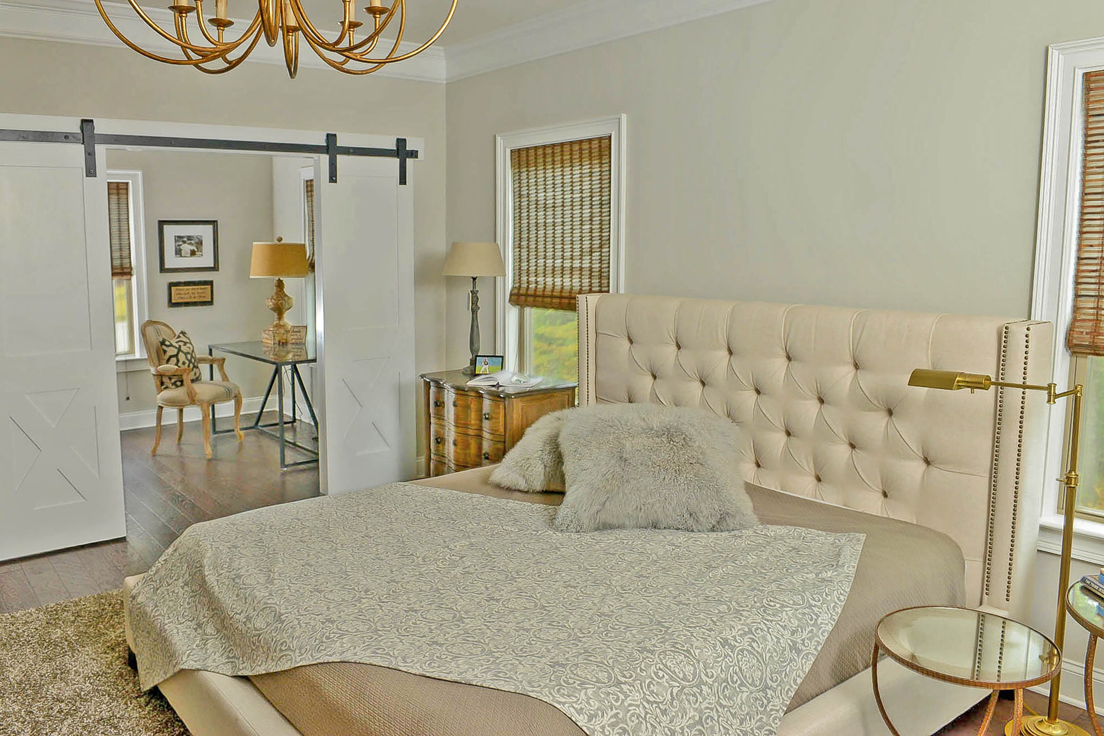 Marcia Harvey describes her master bedroom as comfortable and peaceful. An unexpected feature is the sliding barn-style doors. The brass floor lamp is from Ethan Allen.
