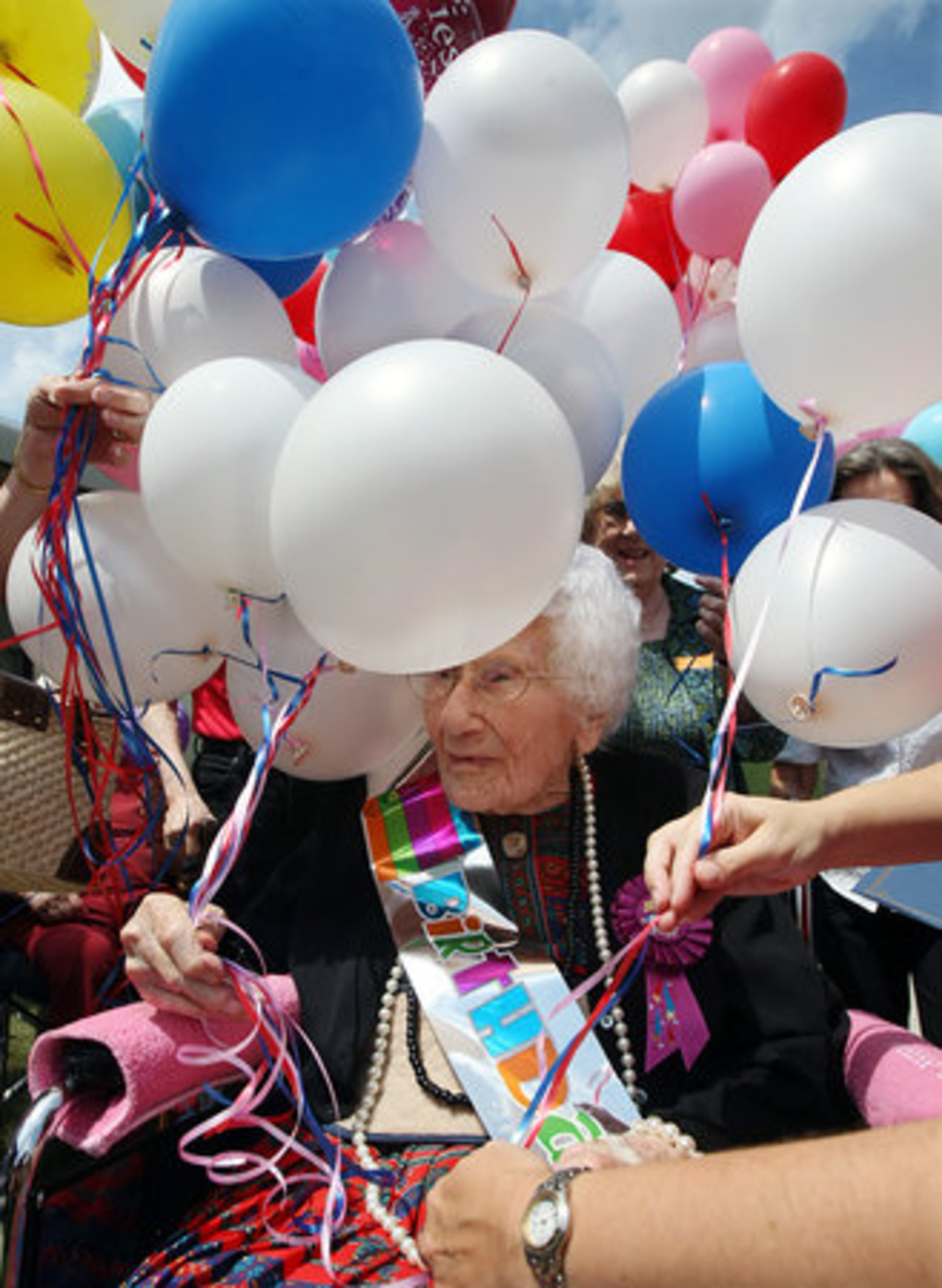 Besse Cooper, who loves balloons, is presented with 113 of them to celebrate her 113th years on this earth.