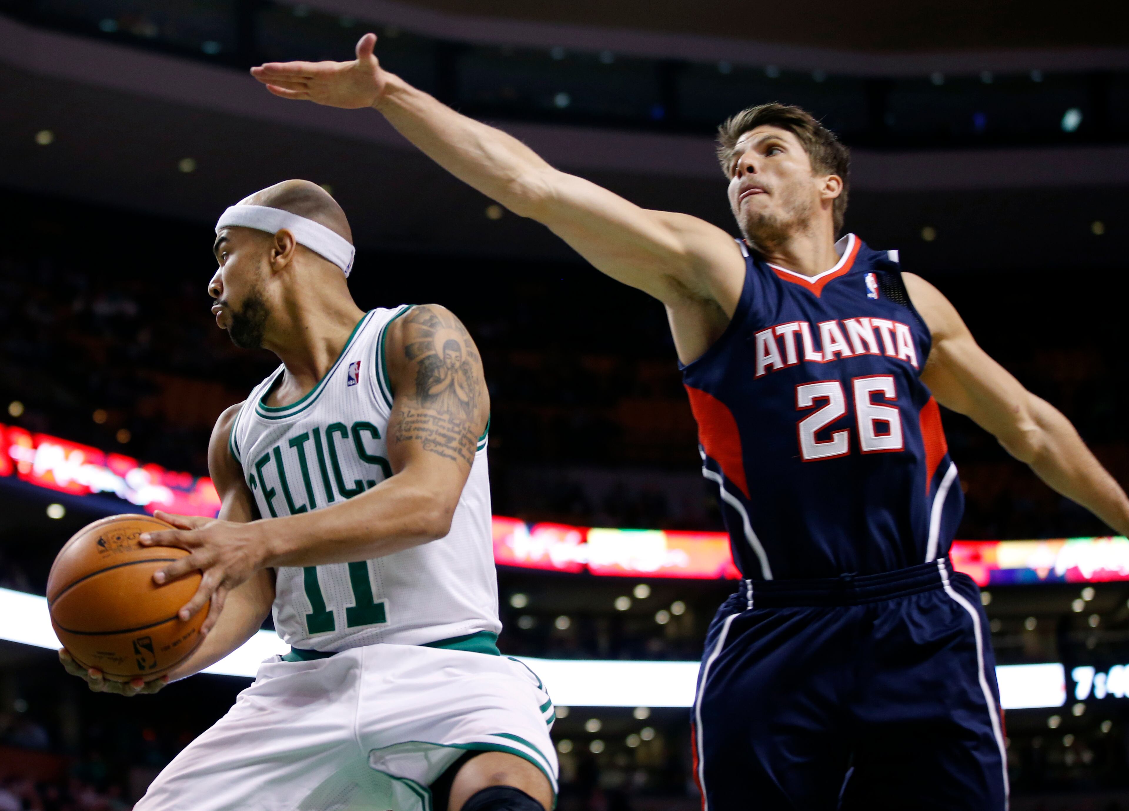 Atlanta Hawks guard Kyle Korver (26) defends Boston Celtics guard Jerryd Bayless (11) during the first quarter of an NBA basketball game in Boston, Wednesday, Feb. 26, 2014. (AP Photo/Elise Amendola)