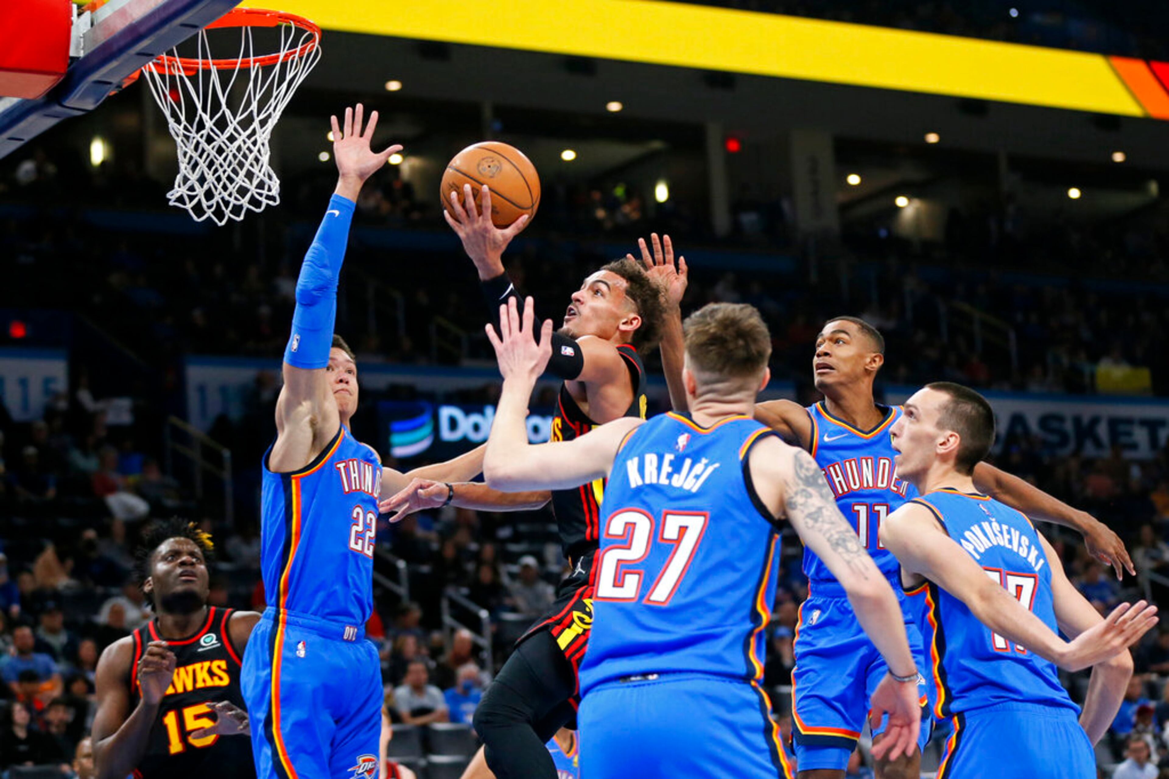 Atlanta Hawks guard Trae Young shoots between Oklahoma City Thunder forward Isaiah Roby (22), guard Vit Krejci (27), guard Theo Maledon (11) and center Aleksej Pokusevski, right, as Hawks center Clint Capela (15) watches during the first half of an NBA basketball game Wednesday, March 30, 2022, in Oklahoma City. (AP Photo/Nate Billings)