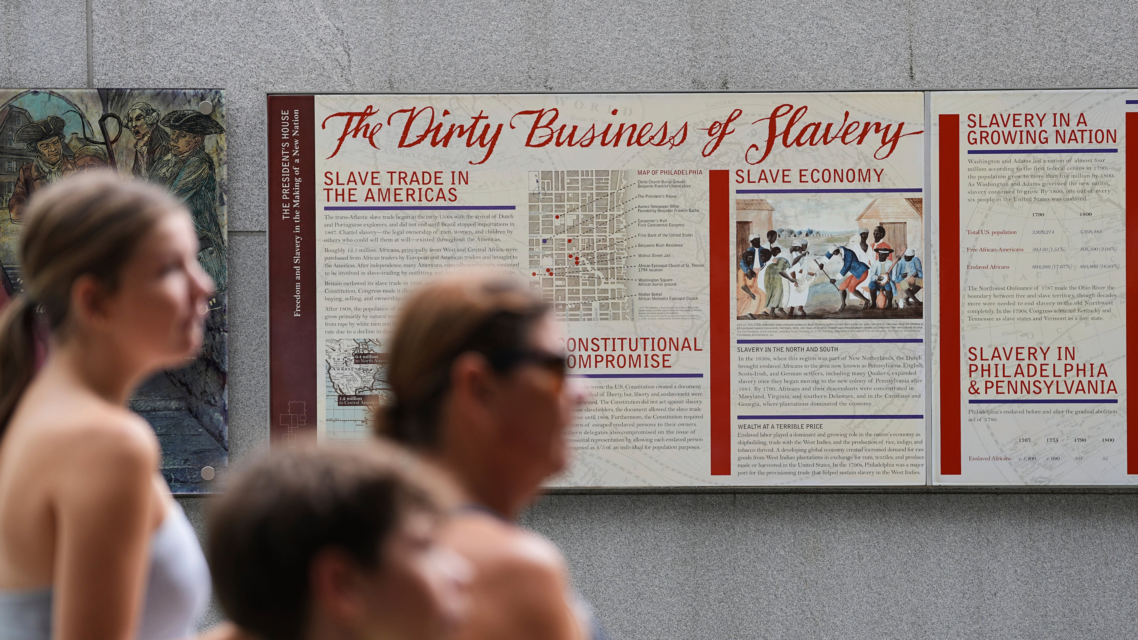 FILE - People walk past an informational panel at President's House Site Tuesday, Aug. 19, 2025, in Philadelphia. (AP Photo/Matt Rourke, File)