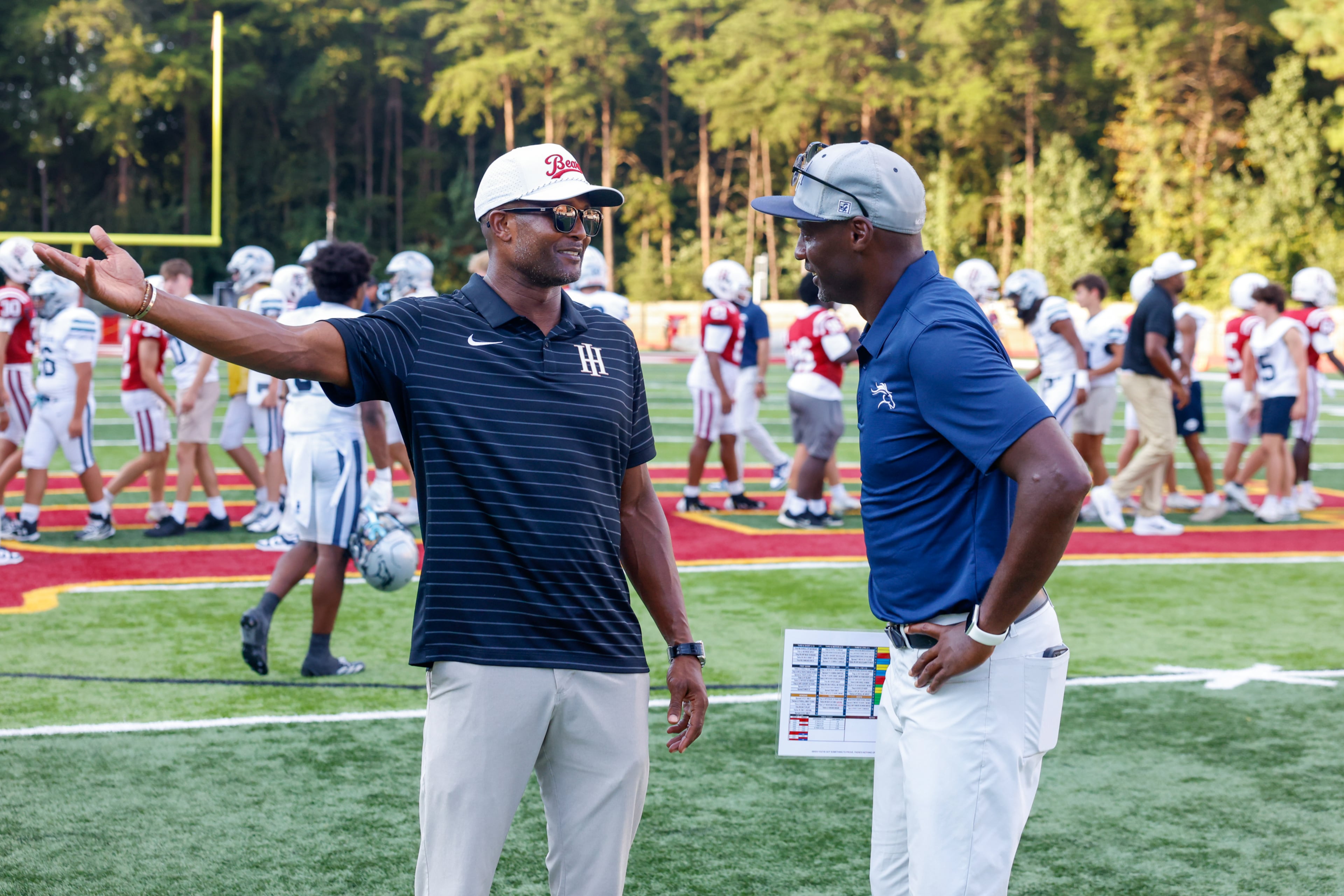 (L-R) UGA great Champ Bailey, a coach for Holy Innocents, speaks with Mount Vernon head coach Terrence Edwards, a former UGA standout, after the Mount Vernon vs. Holy Innocents high school football game at Holy Innocents Episcopal School in Atlanta on Sept. 4, 2026. Holy Innocents won 51-14. (Arvin Temkar/AJC)