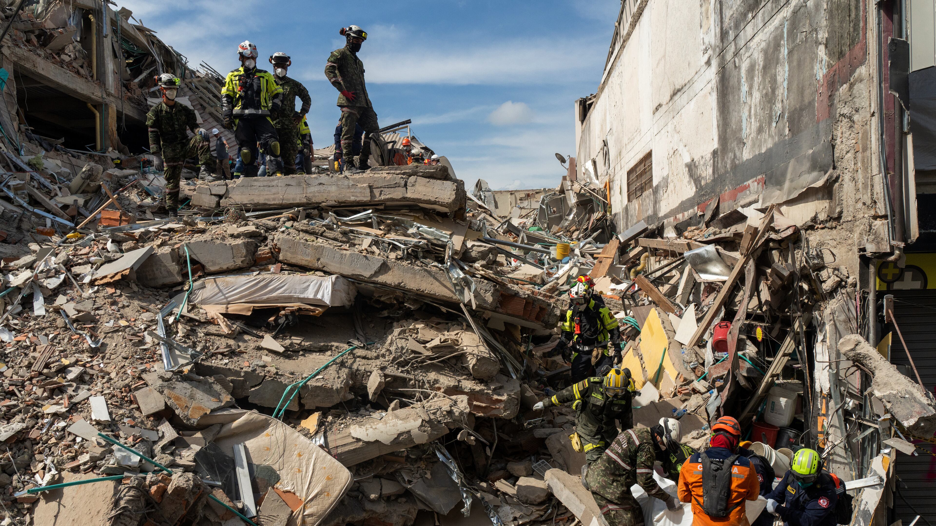 Rescuers carry the body of a victim from the rubble four days after after an earthquake hit Pereira, Colombia, Friday, Aug. 14, 2026. (AP Photo/Brandon Pinto)