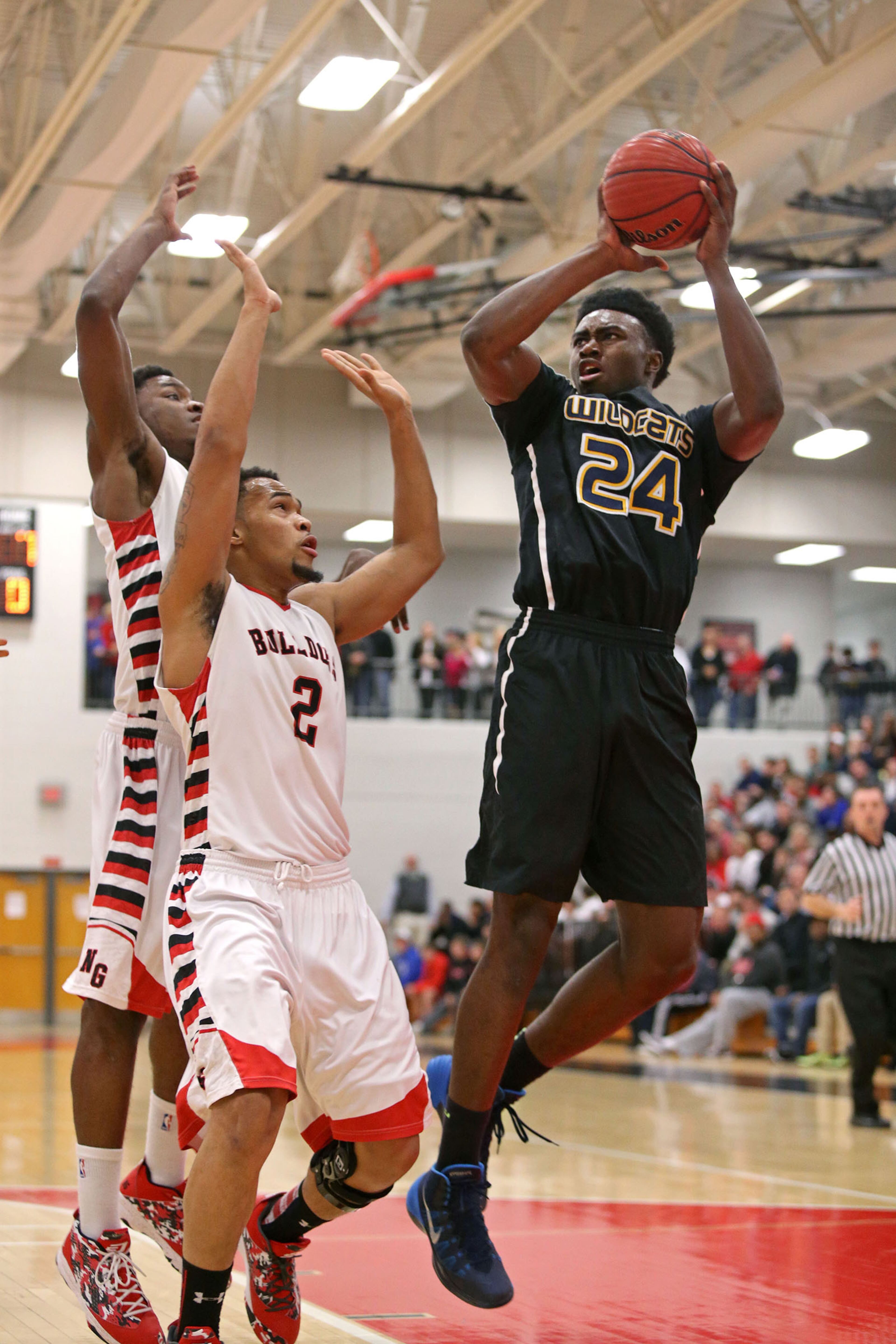 Wheeler's Jaylen Brown (24) attempts a shot over North Gwinnett's Owen Lewis (2) on Feb. 27, 2014, in Suwanee. Wheeler defeated North Gwinnett 61-58 in the third round of the Class AAAAAA state basketball tournament. Brown had 20 points in the game. JASON GETZ / SPECIAL
