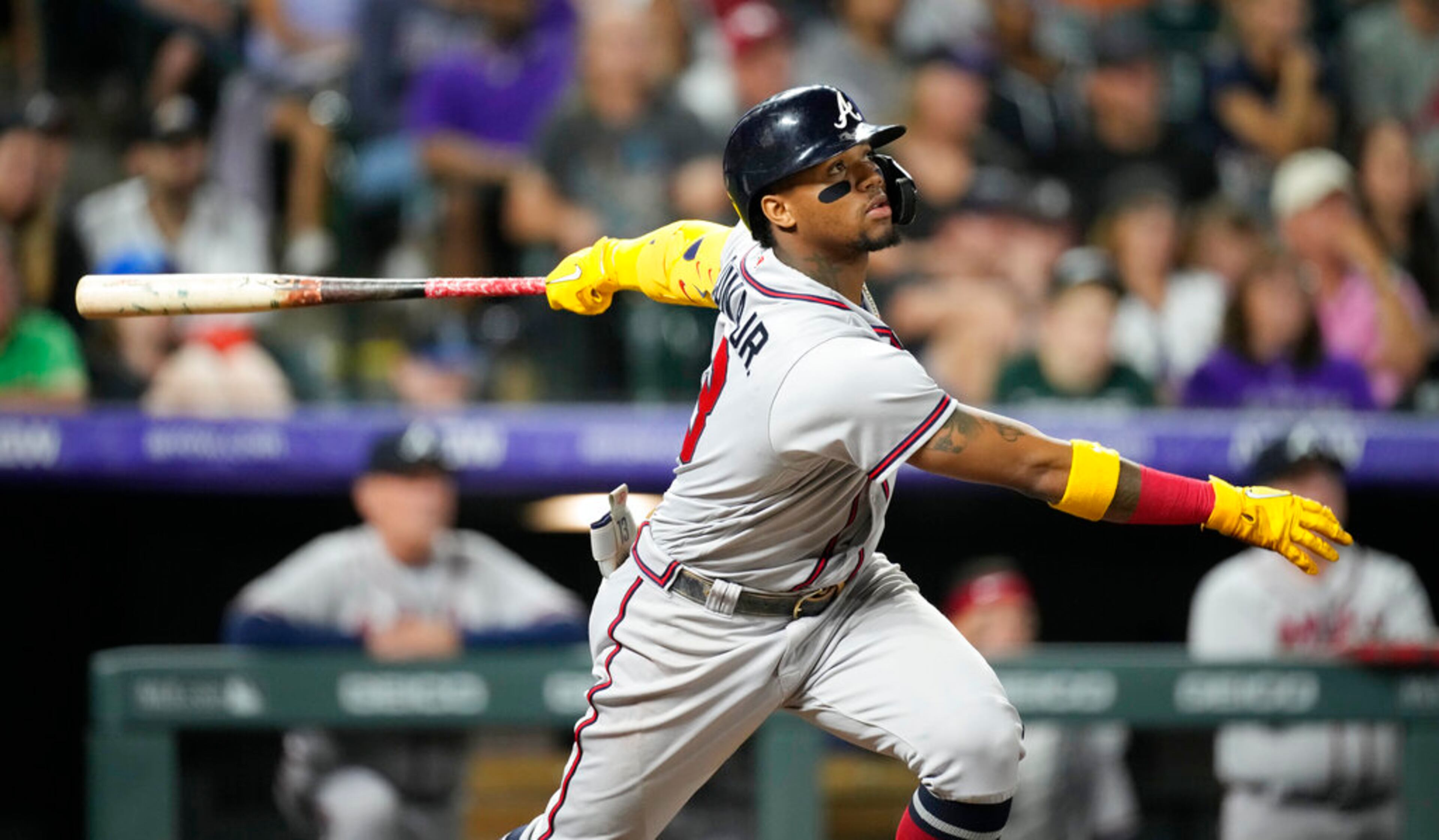 Atlanta Braves' Ronald Acuna Jr. watches his RBI sacrifice fly off Colorado Rockies relief pitcher Alex Colome during the 10th inning of a baseball game Saturday, June 4, 2022, in Denver. (AP Photo/David Zalubowski)