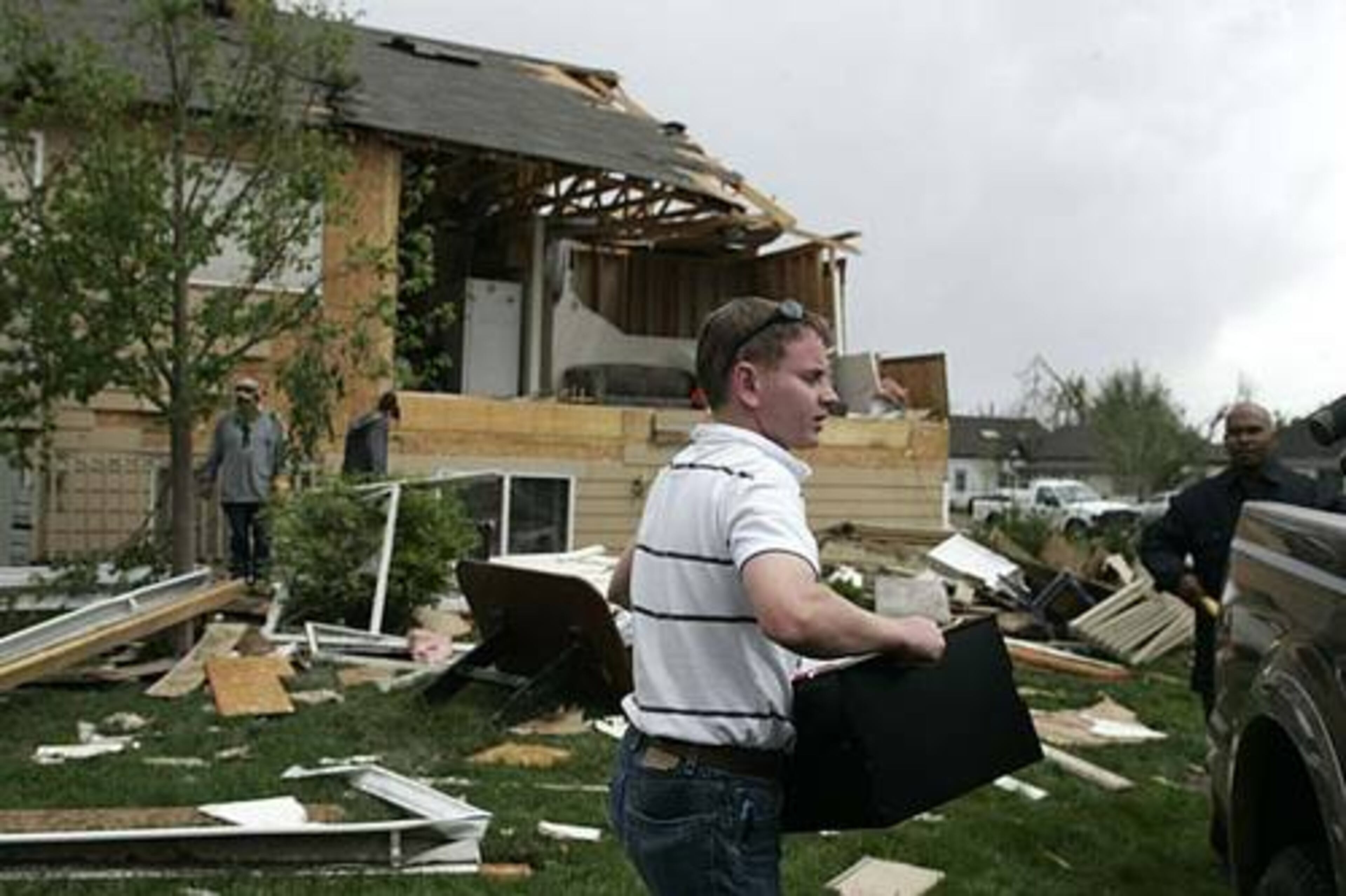 David Strathman loads some of his belongings into a pickup after his apartment was hit by a tornado in Windsor, Colo.