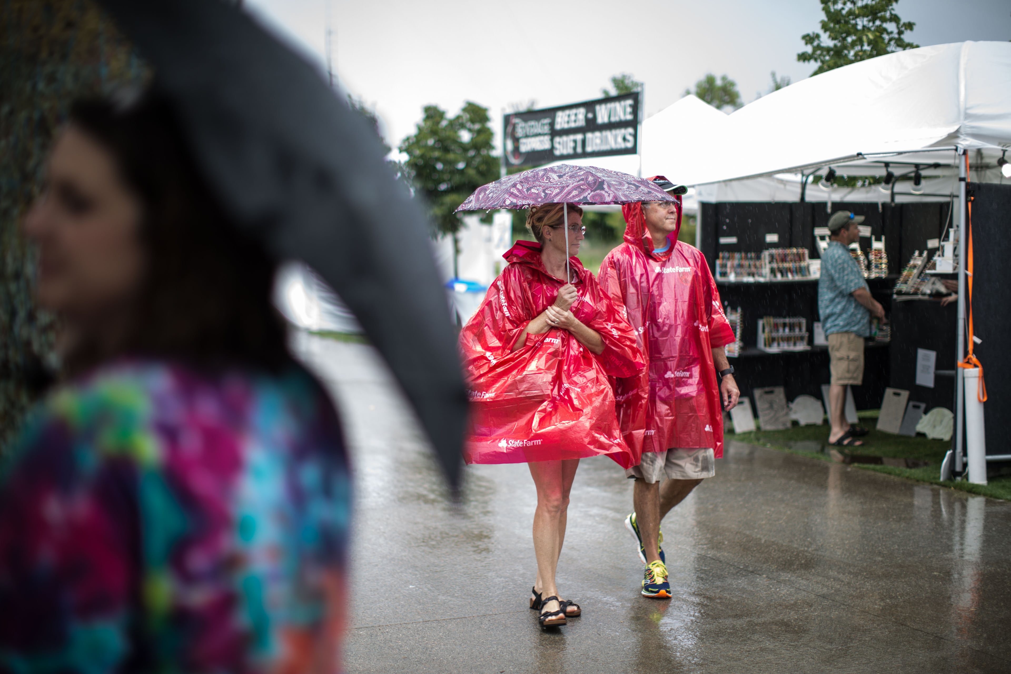 Laura and Todd Young walk together in rain during the Old Fourth Ward Park Arts Festival, Saturday, June 27, 2015, in Atlanta. BRANDEN CAMP/SPECIAL
