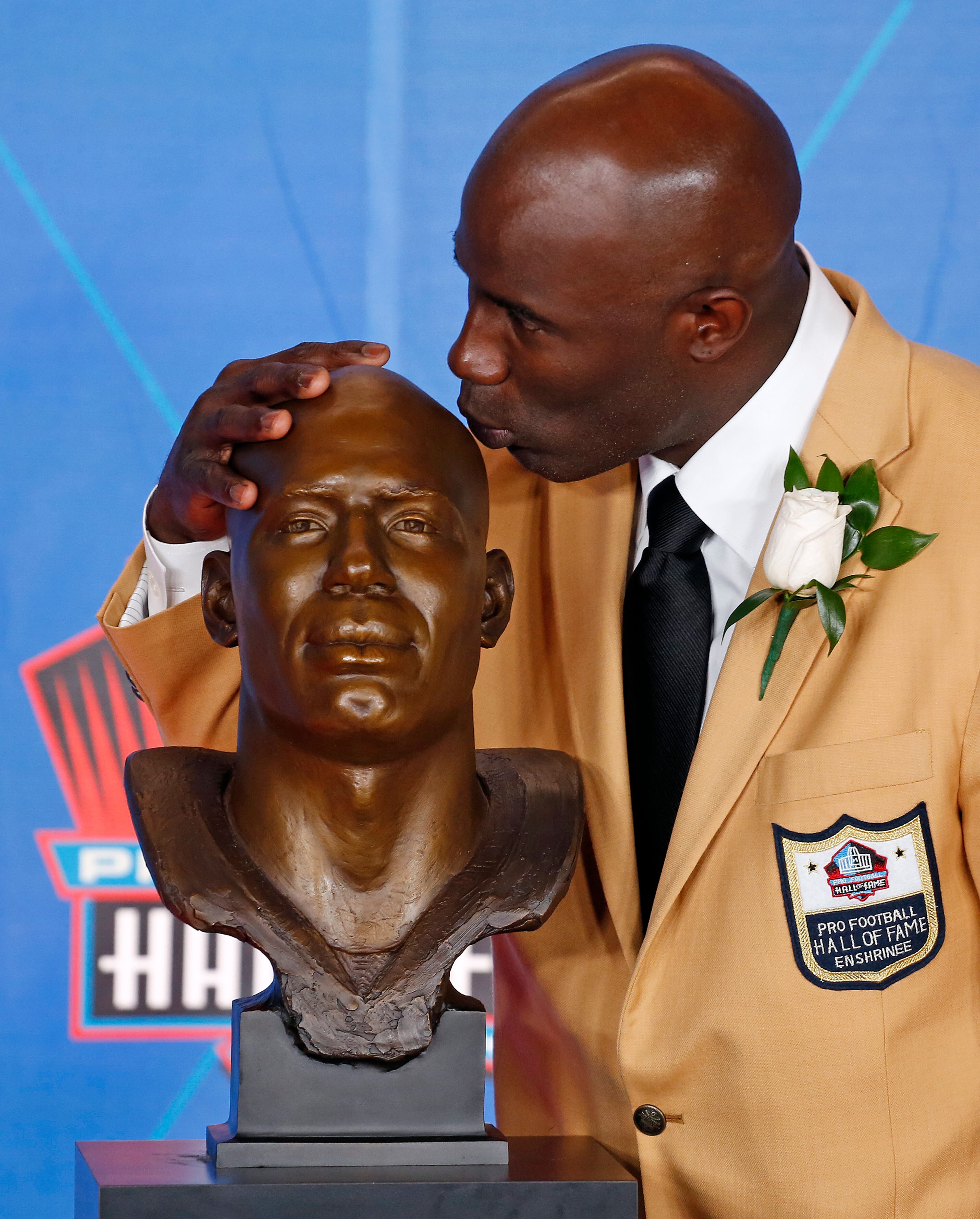 Terrell Davis kisses a bust of him during inductions at the Pro Football Hall of Fame on Saturday, Aug. 5, 2017, in Canton, Ohio. (AP Photo/Gene J. Puskar)