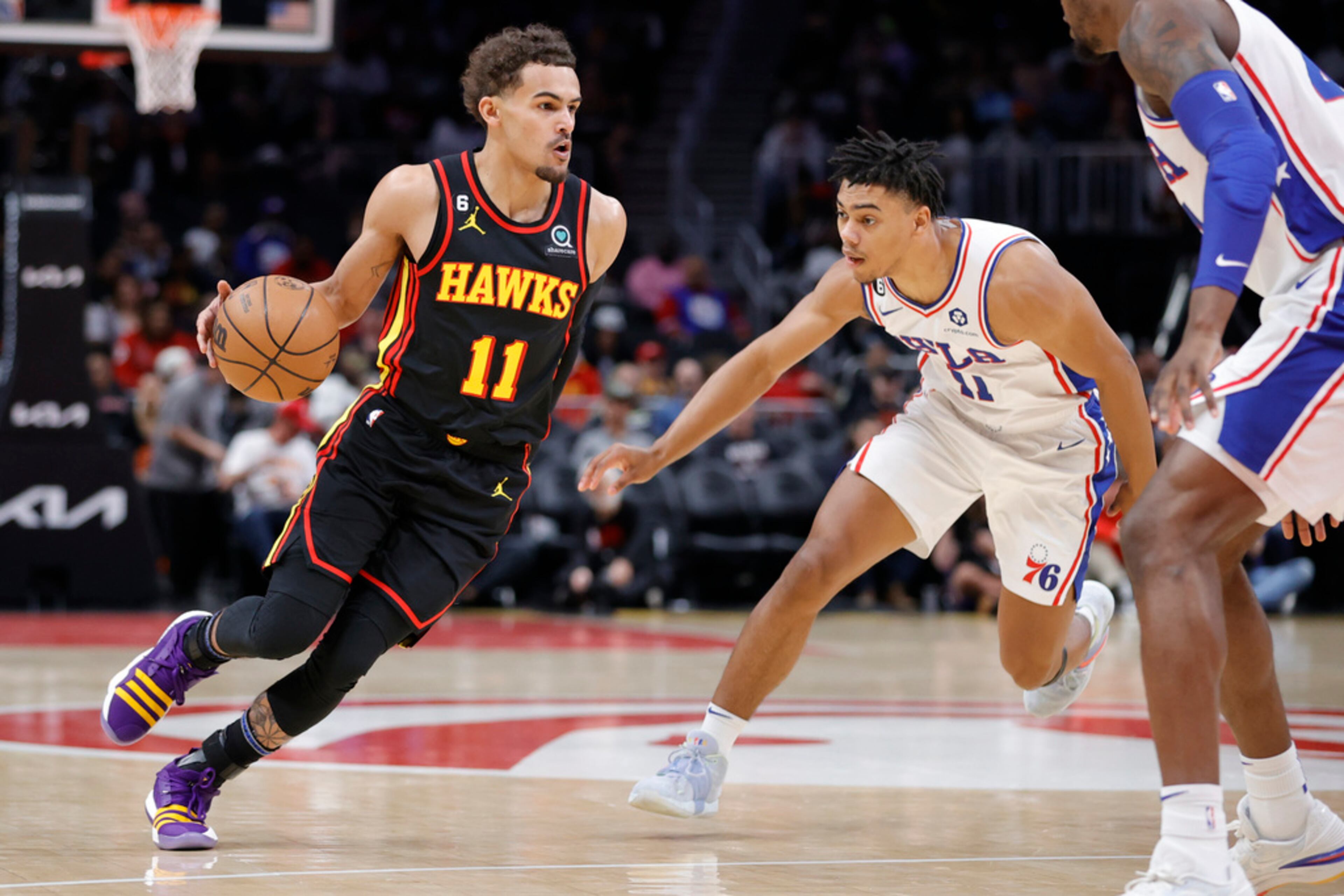 Atlanta Hawks guard Trae Young, left, drives against Philadelphia 76ers guard Jaden Springer, center, during the first half of an NBA basketball game Friday, April 7, 2023, in Atlanta. (AP Photo/Alex Slitz)