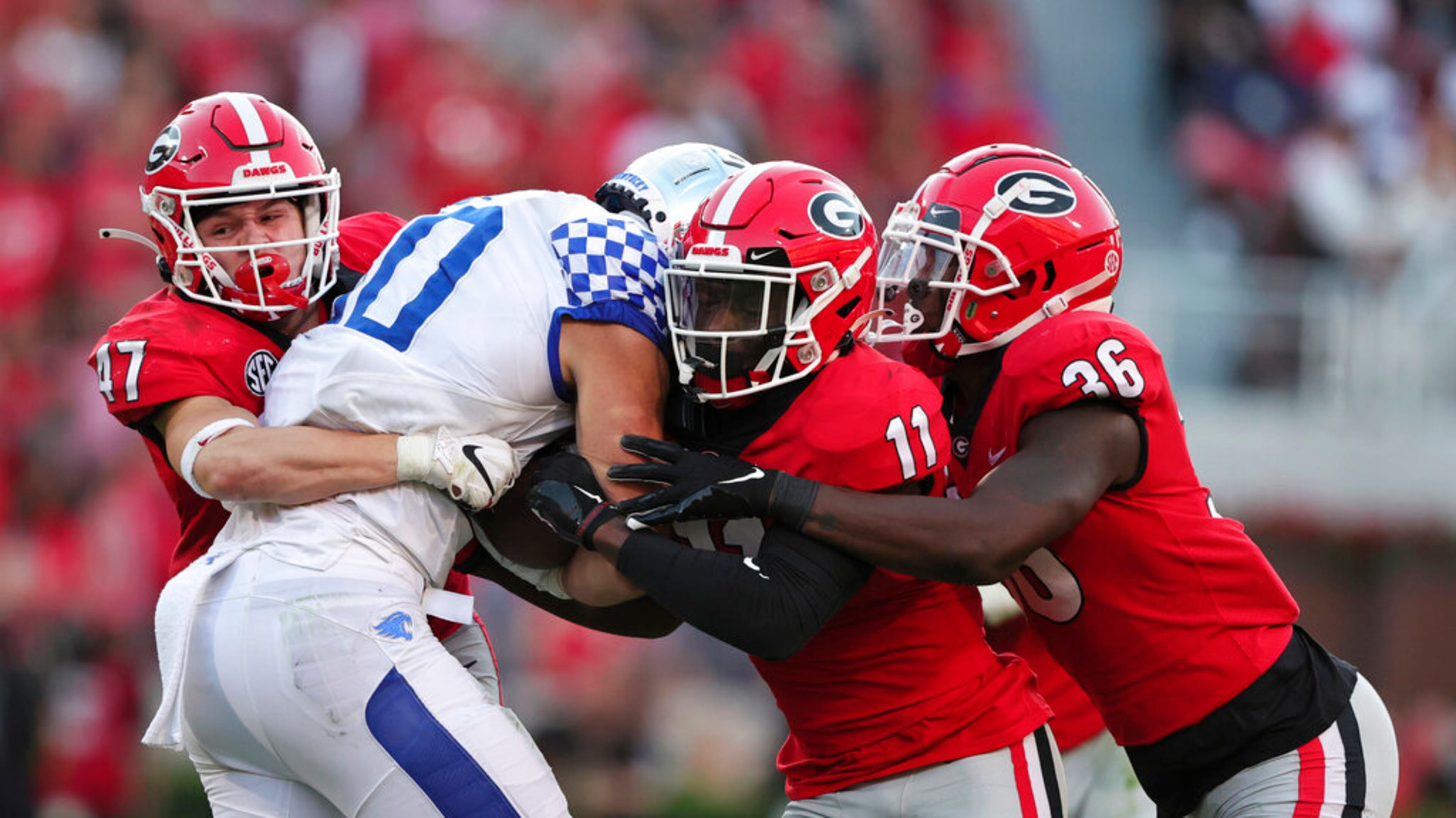 Kentucky wide receiver Chauncey Magwood (10) is stopped by Georgia defensive back Dan Jackson (47), defensive back Derion Kendrick (11), and defensive back Latavious Brini (36) as he carries the ball during the second half of an NCAA college football game Saturday, Oct. 16, 2021 in Athens, Ga. (AP Photo/Butch Dill)