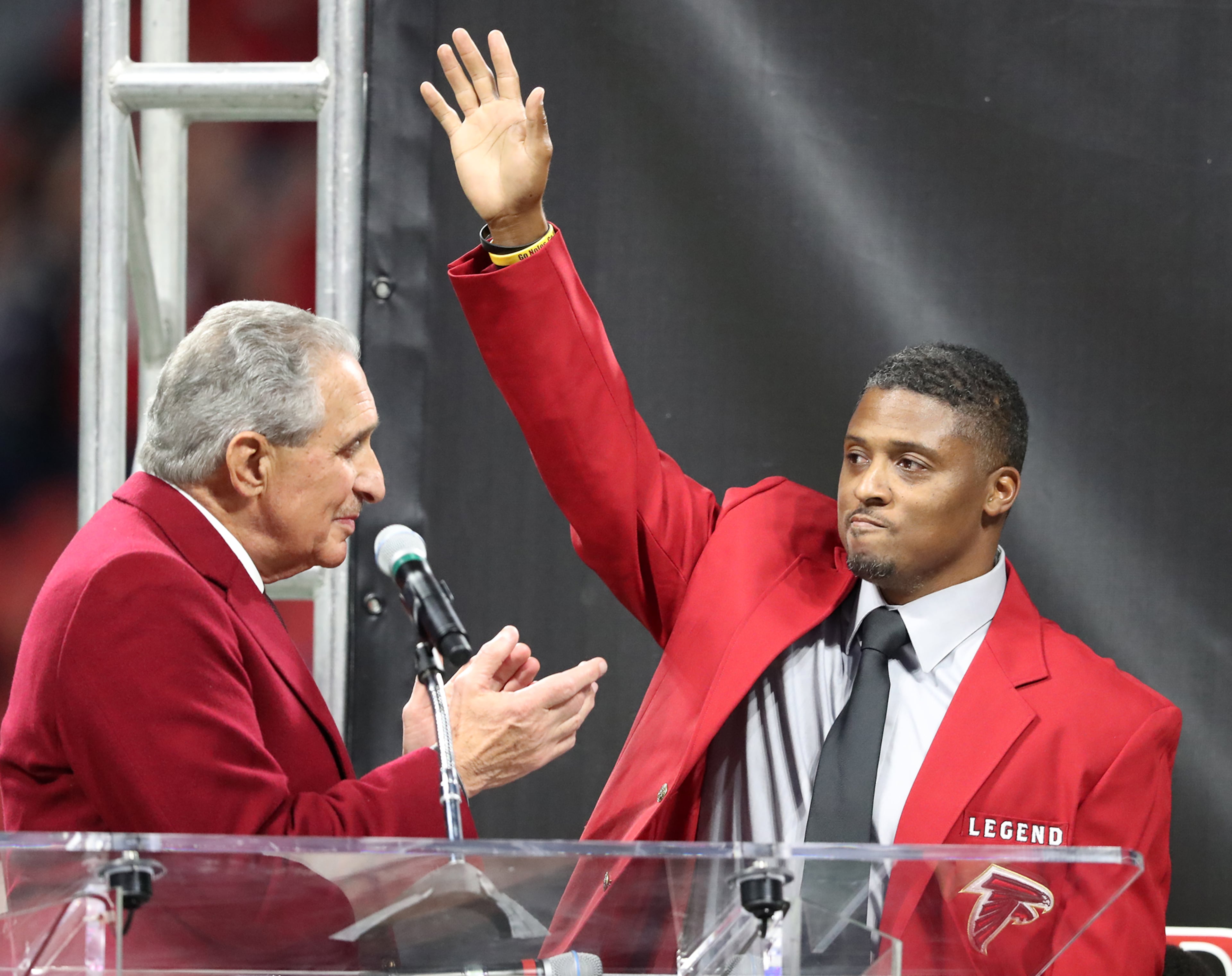 Team owner Arthur Blank applauds former Falcons running back Warrick Dunn as he is inducted into the Ring of Honor during halftime against the Saints in an NFL football game on Thursday, Dec. 7, 2017, in Atlanta. (Curtis Compton/AJC)