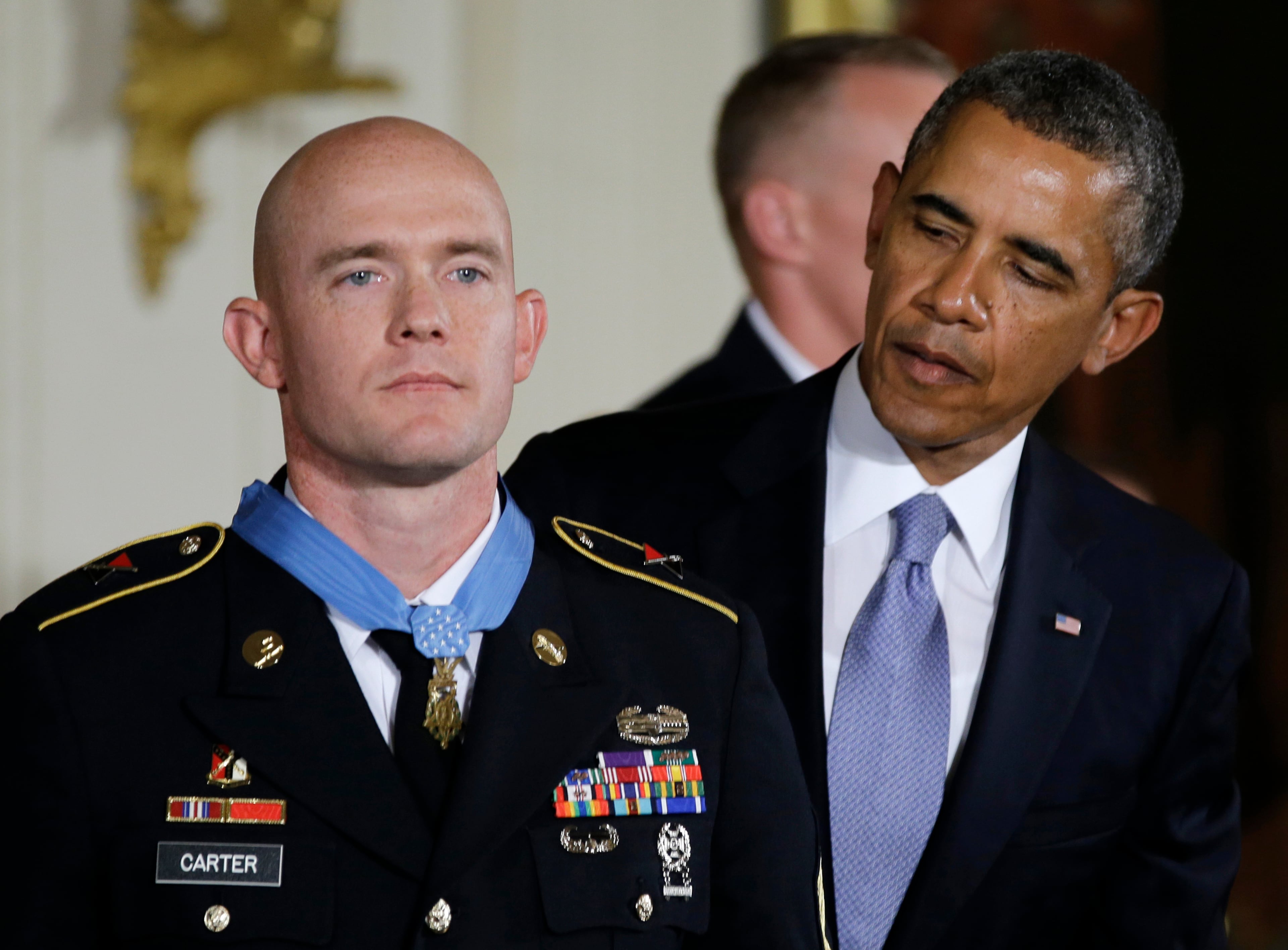 President Barack Obama looks to US Army Staff Sgt. Ty M. Carter after awarding him the Medal of Honor for conspicuous gallantry, Monday, Aug. 26, 2013, during a ceremony in the East Room of the White House in Washington. Carter received the medal for his courageous actions while serving as a cavalry scout with Bravo Troop, 3rd Squadron, 61st Cavalry Regiment, 4th Brigade Combat Team, 4th Infantry Division, during combat operations in Kamdesh District, Nuristan Province, Afghanistan on Oct. 3, 2009. Carter is the fifth living recipient to be awarded the Medal of Honor for actions in Iraq or Afghanistan. (AP Photo/Carolyn Kaster)