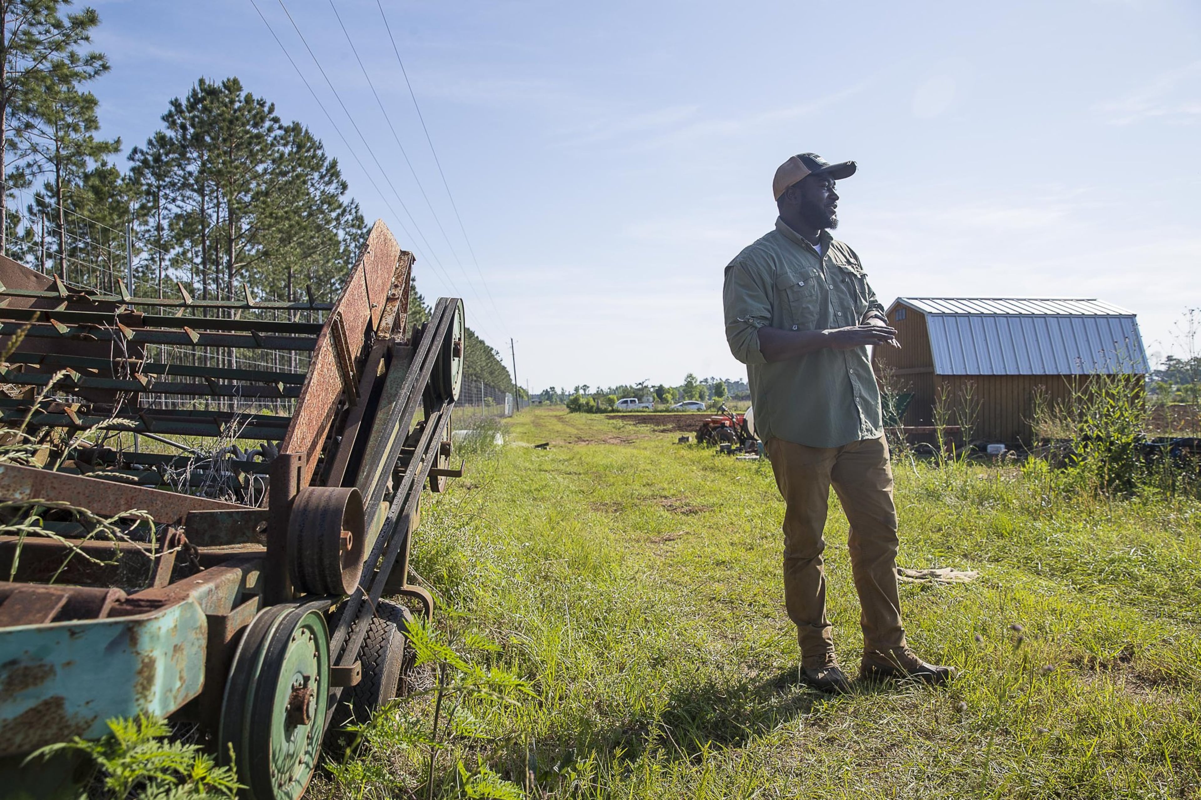 Sedrick Rowe talks farming at a 10-acre property he is leasing to own in Albany. Alyssa Pointer/AJC)