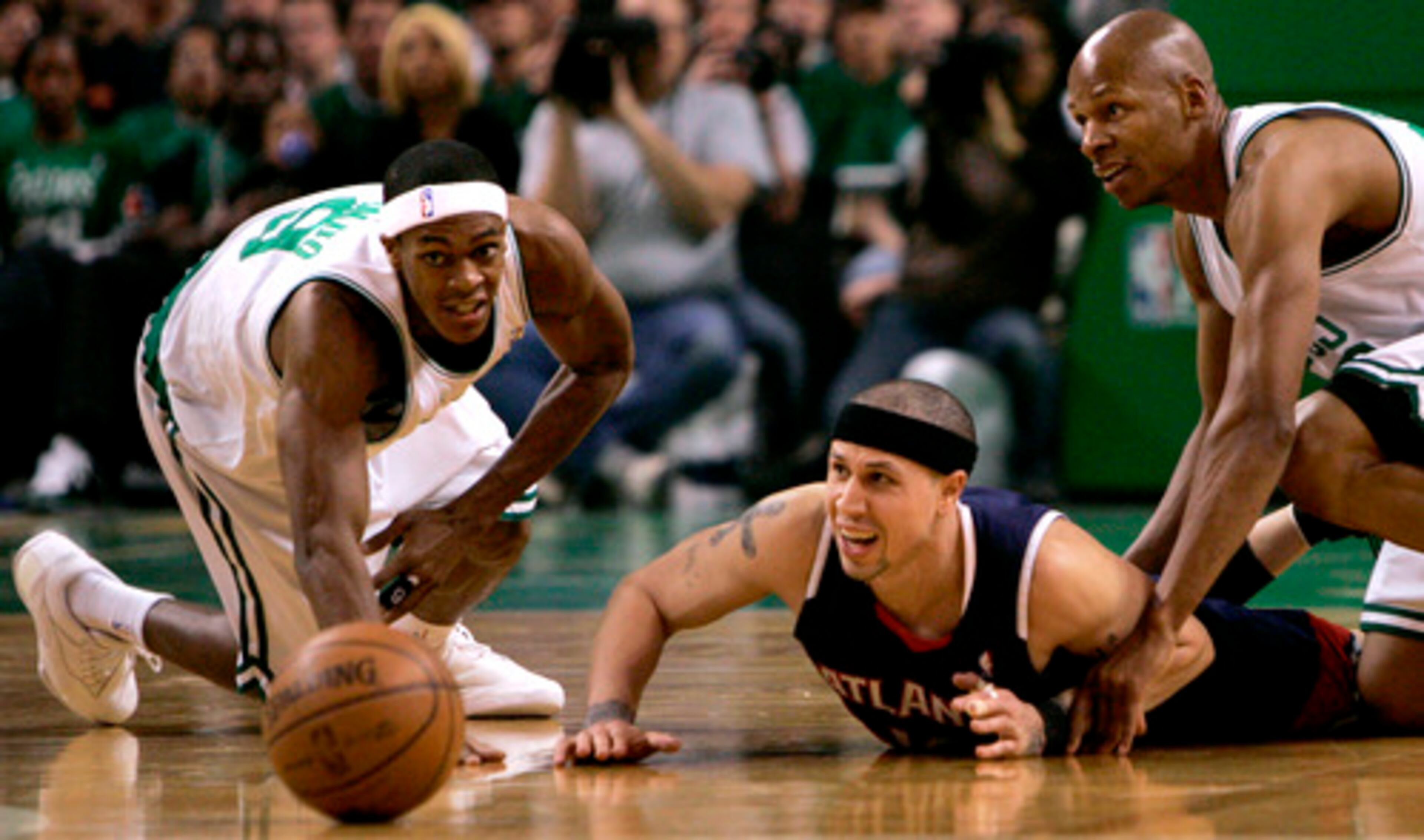 Hawks guard Mike Bibby (center) loses control of the ball as he is sandwiched between Boston's Rajon Rondo (left) and Ray Allen.