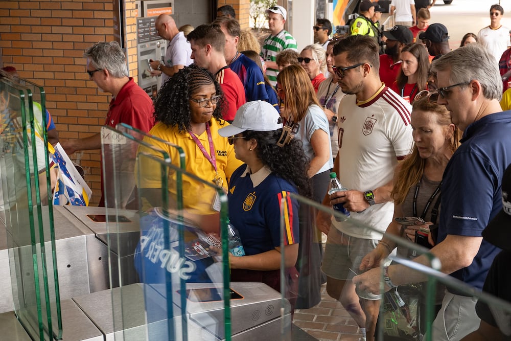 A MARTA employee helps fans access the Vine City station as they commute to attend a FIFA World Cup match in Atlanta. (Ben Hendren for the AJC)