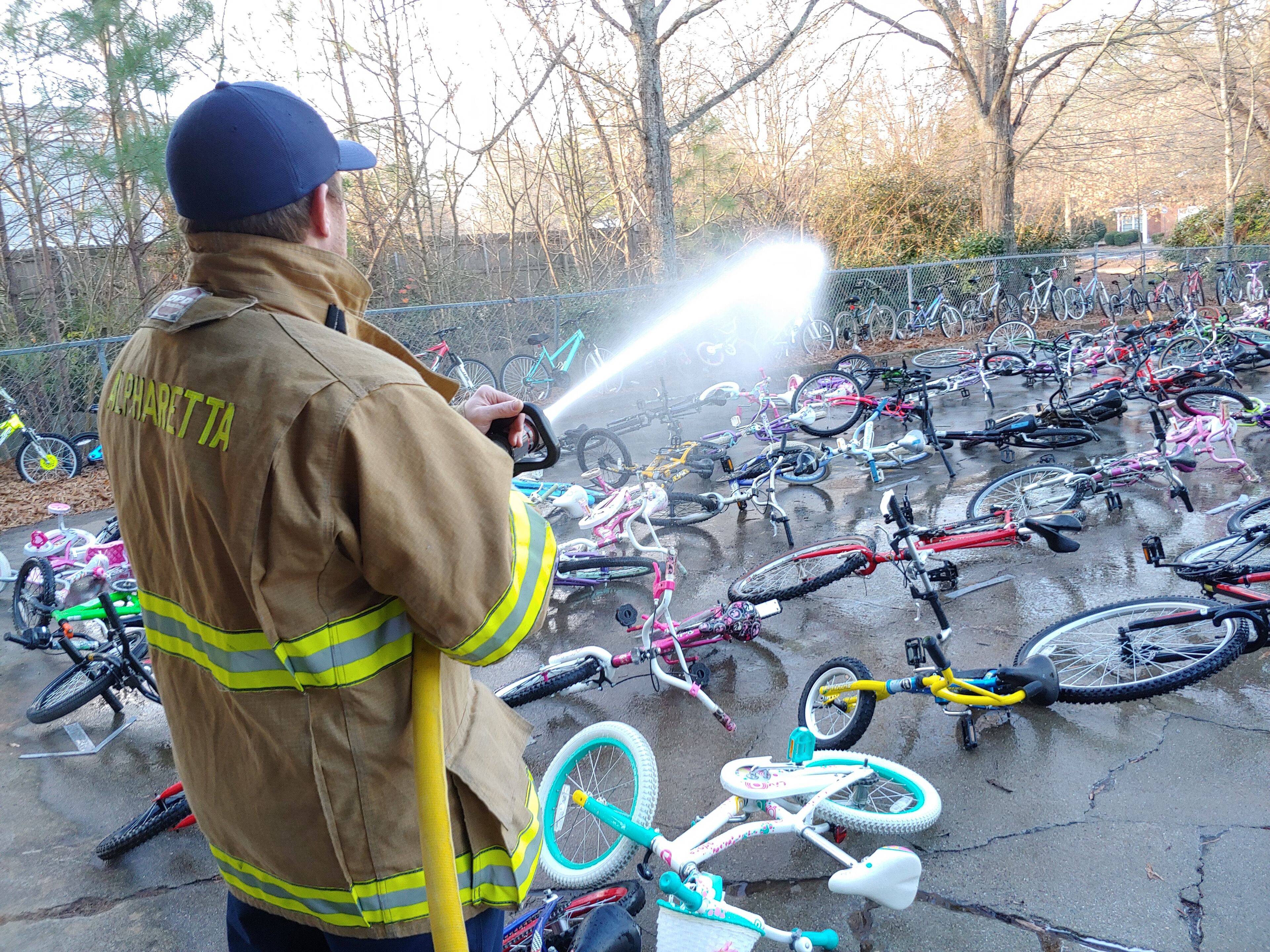 An Alpharetta firefighter gives the bikes a good cleaning to get them "Santa ready."
Courtesy of Bike Alpharetta