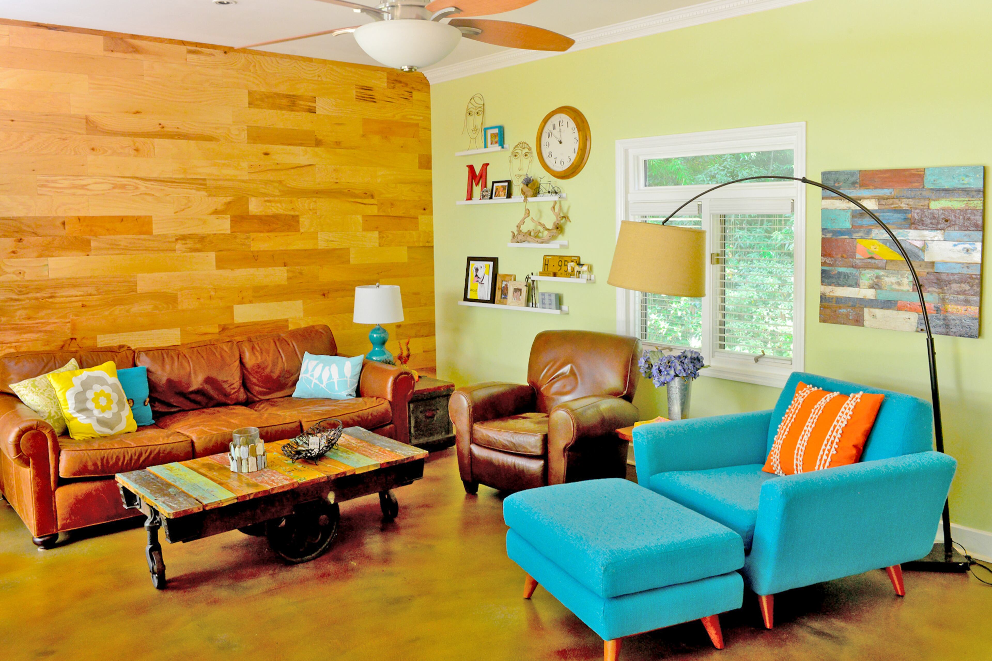 Finny Moore and her husband Ron renovated their Ardmore Park home after doctors diagnosed her cancer as fatal. After going into remission in 2014, the couple continued working on their midcentury modern home. The turquoise love seat and ottoman from Joybird in their living room add colorful midcentury modern character. The wood wall, behind the brown leather sofa from RH, is actually engineered flooring. It adds texture to the living room without being too rough and rustic in their eclectic living space.