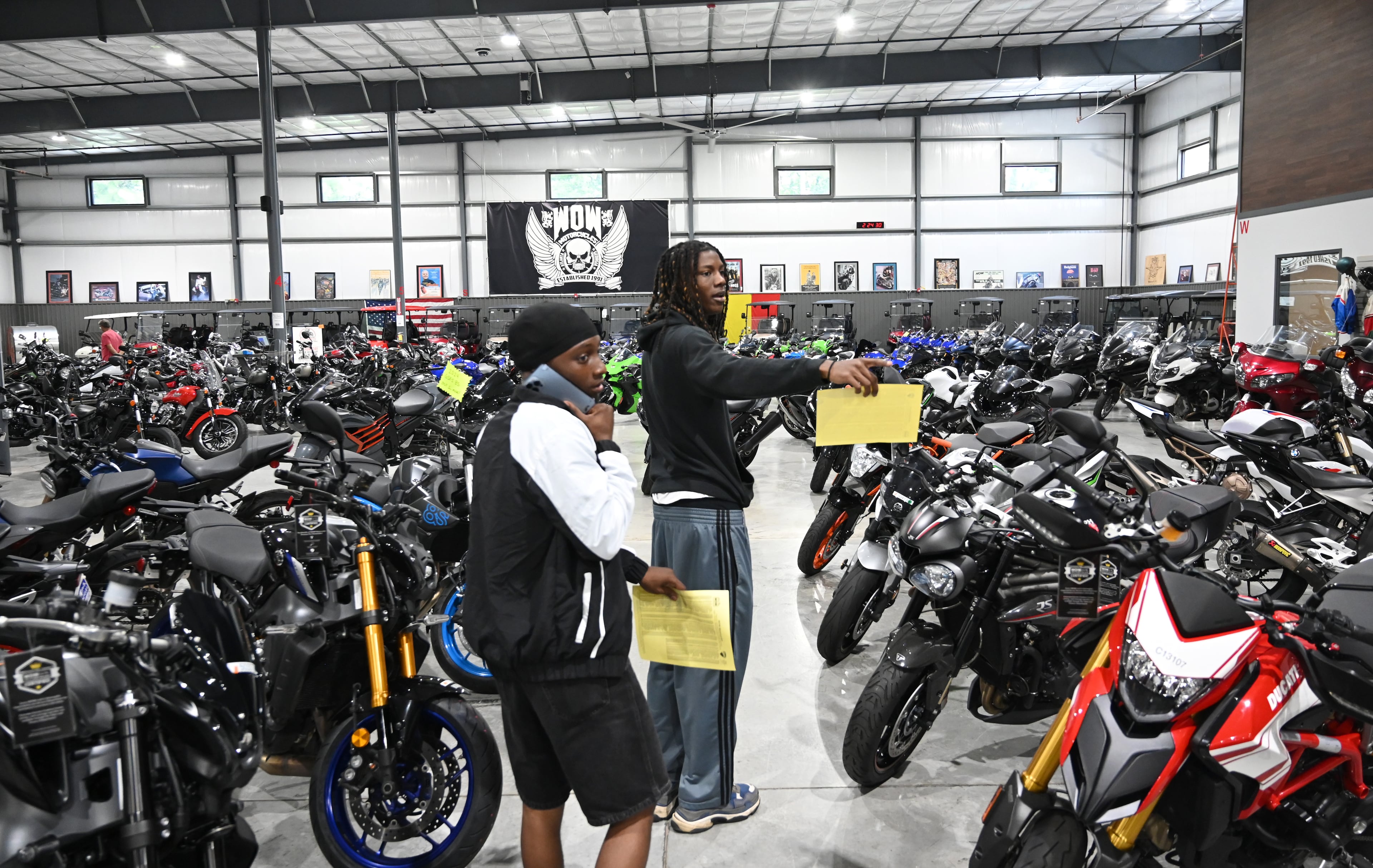 Customers Kim Peterson (left) and Dallas Greene visit WOW Motorcycles on Thursday, July 24, 2025, in Marietta. Motorcycling is a small community, but it allows people from all walks of life to instantly bond, according to Candy Hunter. (Hyosub Shin/AJC)