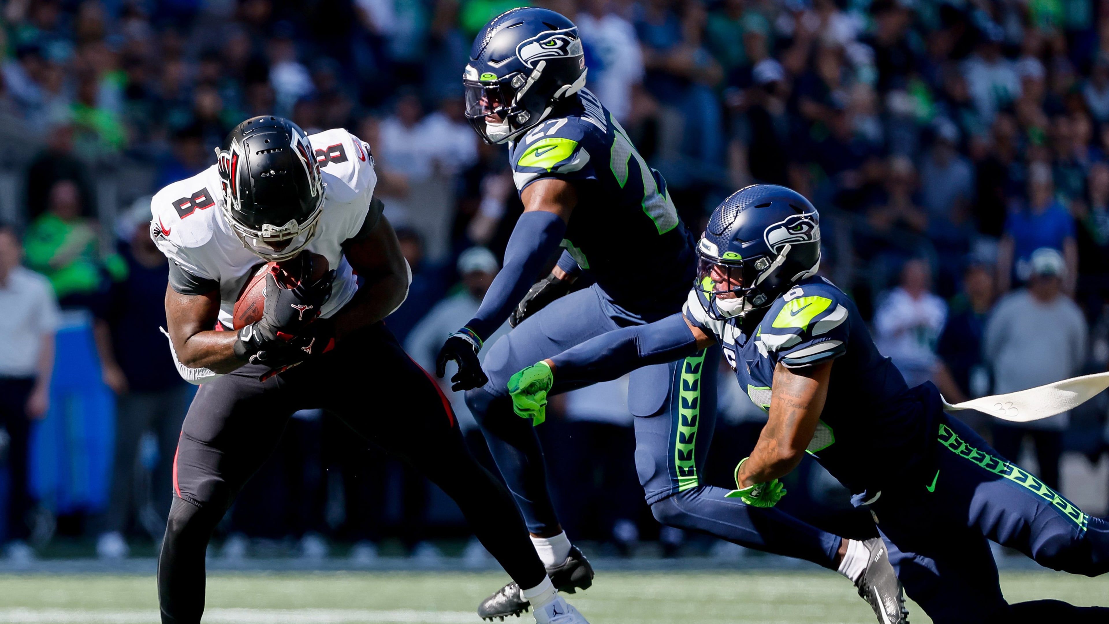 Seattle Seahawks safety Quandre Diggs, right, and cornerback Tariq Woolen try to catch Atlanta Falcons tight end Kyle Pitts as he picks up a long gain during the second quarter, Sunday, Sept. 25, 2022, at Lumen Field in Seattle. (Jennifer Buchanan/The Seattle Times/TNS)